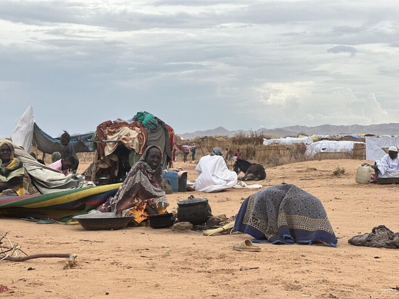 En kvinna bygger ett provisoriskt skydd i Tawila i juli 2025.