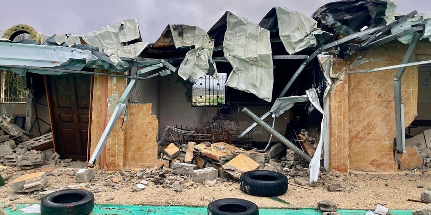 Ett svårt skadat bostadshus med raserat tak, förstörda väggar och bråte efter en explosion eller beskjutning.
