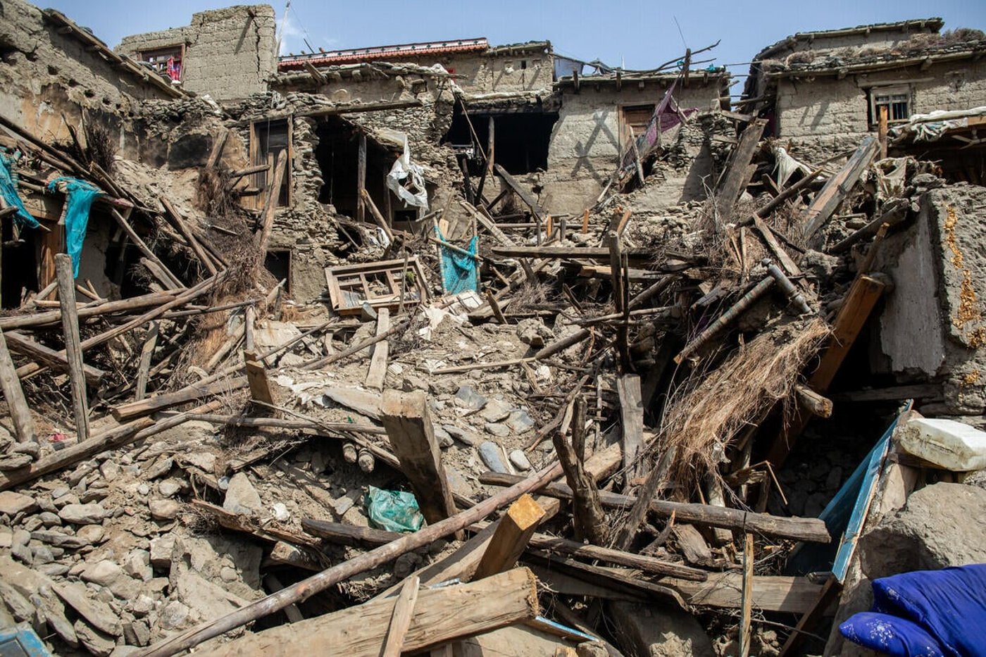 Bilden visar flera bostadshus som har rasat samman.  Delar av byggnaderna står fortfarande kvar, men är kraftigt skadade och instabila.