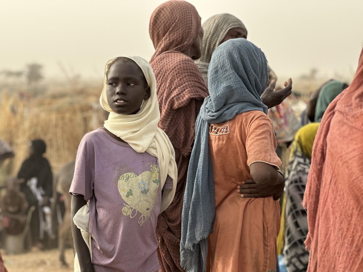 Fördrivna barn och vuxna samlas i ett tillfälligt bosättningsområde efter att ha tvingats fly undan våld och osäkerhet.