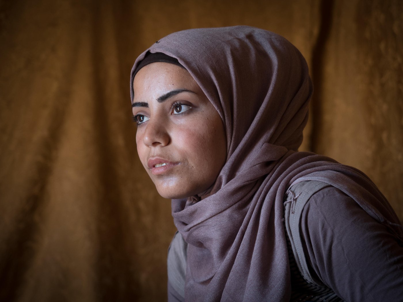 This is Samar. A 20-year-old girl from Idlib in northern Syria. In 2012, she escaped the war in Syria and fled to safety in Lebanon with her family. She now lives in a tent in an Informal Tented Settlement (ITS) in the Bekaa valley with her parents and five siblings. “My family and I left Syria because of the fighting and to save the children and remain alive. I felt sad and it was painful to leave my country, my friends, and relatives”, says Samar.   

“When I was younger I dreamt of becoming a lawyer but after I fled from Syria this dream was crushed. I am the breadwinner of the family now, so I can't tell them I want to pursue my dream.” Instead of studying in University she is spending six hours a day, six days a week, doing manual labour in agriculture in exchange for living for free on the land of the farmer. Samar and her sister are the breadwinners of the family of eight since her father is unable to work because of his poor health. The main income is from the food allowance from the World Food Programme and also UNHCR CASH programme. 

“I worry a lot about my father because of his health condition. I worry about my grandma who is still in Syria. I worry about not being able to renew my residency permit. I worry about the situation in Syria. I worry about my friends in Syria because they are far away from me.”

The war did not only crush her dream of becoming a lawyer, it also stole the love of her life, Said. The man she was about to get engaged to. The love of her life. “I had pictured my life with this man to be very beautiful. Any girl would have dreamed about it. He had a good personality, he was elegant. Every time when I used to see him I felt true happiness.” Said got killed in an explosion. “I feel a huge sorrow. The first two years were very difficult for me. I couldn't accept that it happened,” Samar says quietly. “At first when I think about him, to our memories, I feel happiness. But then, I feel sorrow because this is something that I lost, he is gone. After Said died, I don't trust anymore, I haven't been able to believe in love anymore.”

Despite her worries and her sorrow Samar has a drive in her to make the future better. “I am always optimistic for the future, I will never stop my optimism,” she smiles. “Said, may his soul rest in peace, used to love me because I was always an optimist. Life has to continue no matter what and he never liked to see me sad. He loved to see the smile on my face and not that I would be depressed.”
			
So, Samar uses her optimism and drive to make life better for her family and the ones living in her ITS. She is an IFP (information focal point) for NRC. “I help people with hygiene promotion practices, I give them awareness session, and I encourage them that we together should help out to collect garbage to prevent diseases. If a fire breaks out, I put it down. If someone hurt themselves I support with first aid. I check the latrines to make sure they are clean. I give the children hygiene promotion session about how to wash their hands. Also, if parents want to register their children in school I help them. If someone needs to get to the hospital I support them.  If someone wants to do birth registration I help them talk to the lawyers,” explains Samar. In addition to this, she also teaches a young girl in the ITS to read and write. 
Samar dreams of moving back home to Idlib. “Syria was very beautiful, anyone would have wished to live there. It was very safe. Boys and girls would be out playing till late nights with no problem. No one would cause them harm. Syrian people were very generous and they had high manners. Life was very beautiful. However, I am afraid that Syria won't return to what it was before.”				
	
Photo: Ingebjørg Kårstad/NRC.