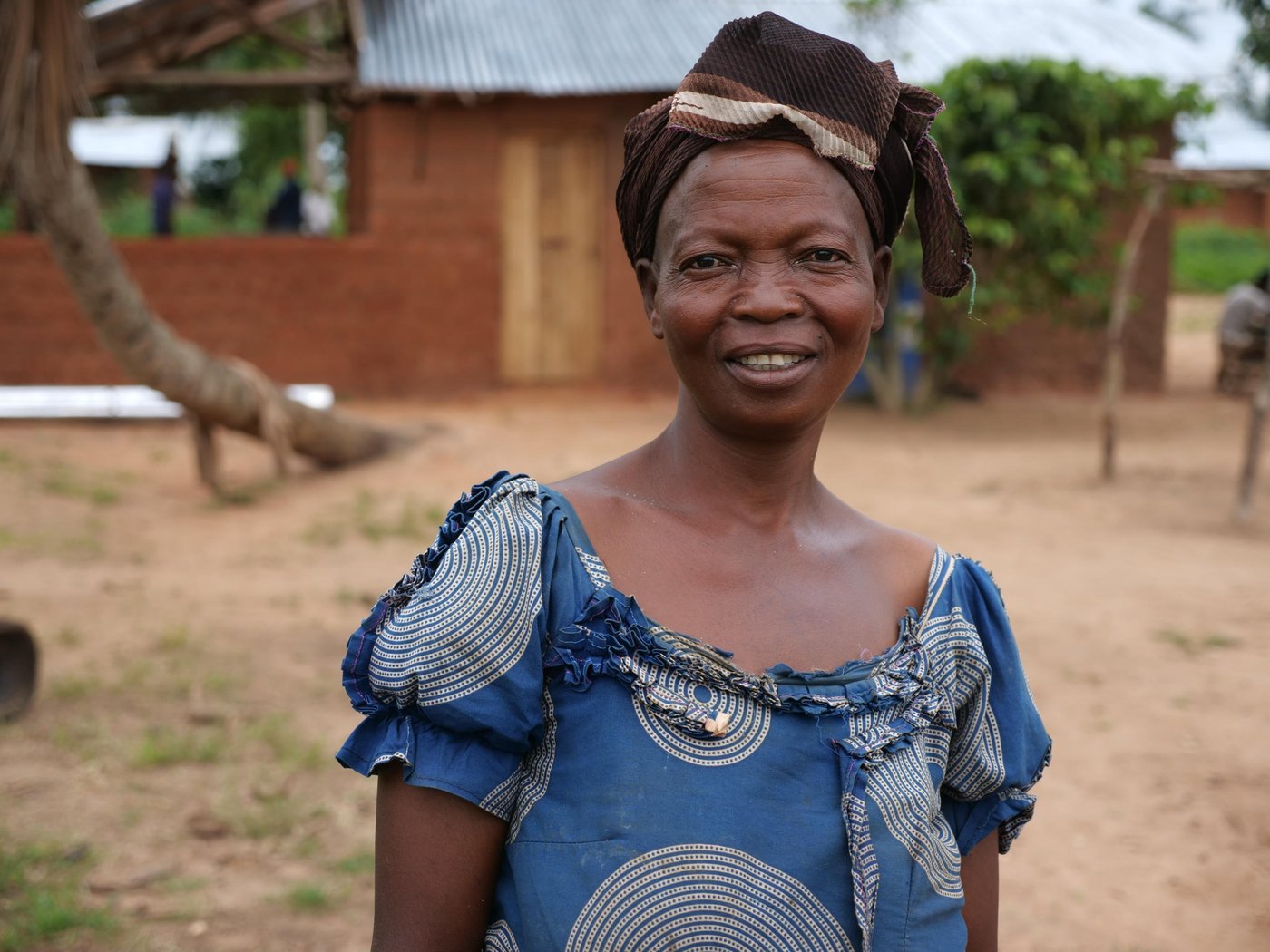Monique poses for a photo behind her new house.

Photo. Itunu Kuku/NRC