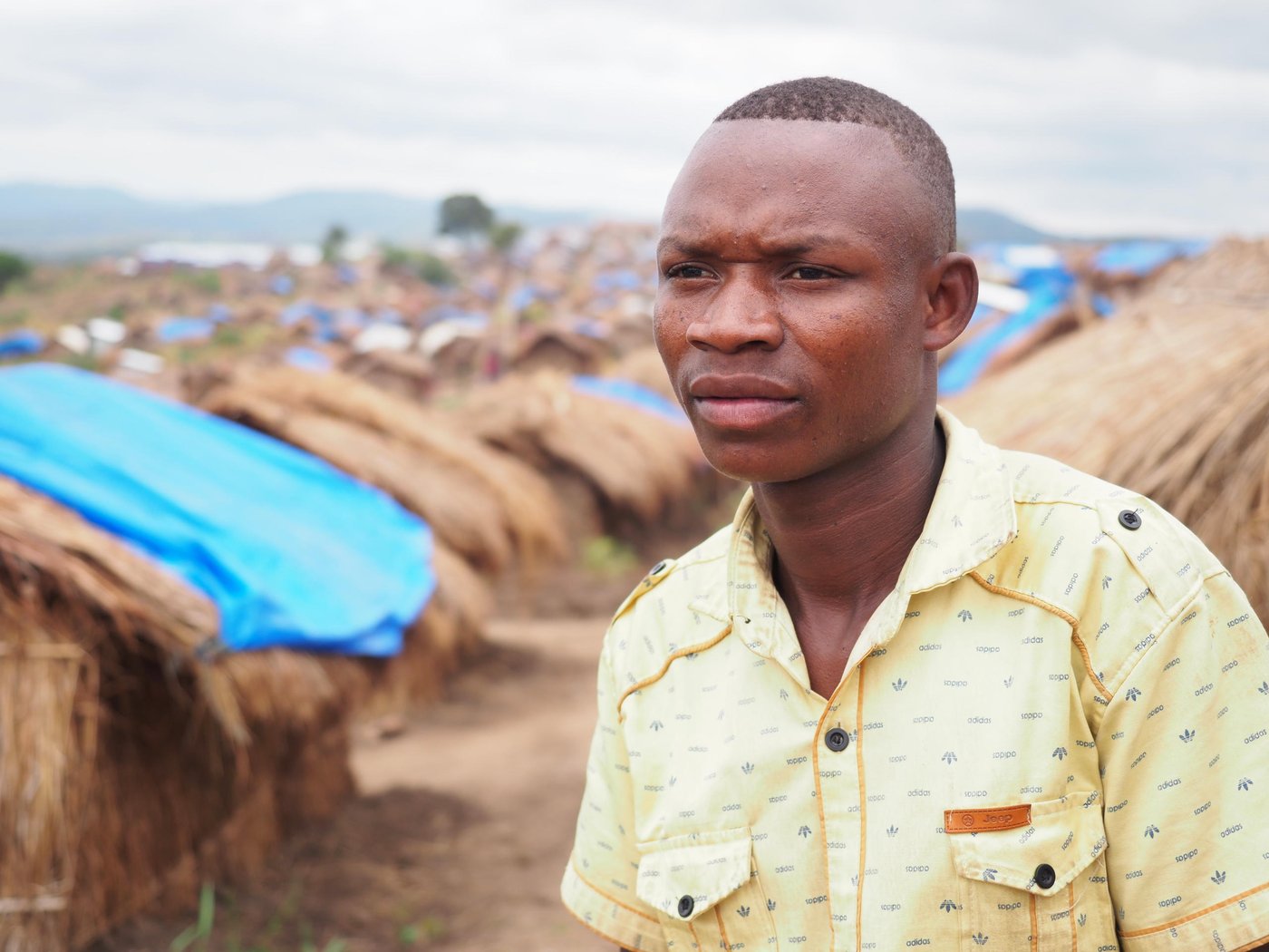 Martin is 19 years old and lives in the Mwaka IDP Camp in the outskirts of Kalemie city. Martin has fled two times in his life; one time when he was a small child which he does not remember much of, and the second time was last year.
He now lives in a small hut and struggles to find food every day. There’s a lack of food and to survive, he has to wake up early in the morning and go out to cultivate or fetch firewood that he can sell in order to earn some money. If he is lucky, he can earn 1000 Congolese franc, which is about 60 cent (USD). If he is lucky, he can get one meal a day, but there’s days he doesn’t eat anything.
Martin came to the camp last year after he fled from his village Kuzo. There was clashes between ethnical groups in the Tanganyika province where he used to live. The groups attacked during the night and Martin immediately fled into the bush and ran without looking back. Everyone in the village ran different directions and Martin saw many people who was injured. Martin’s father ran in the same direction as him, while his mother ran in an opposite direction. It was total chaos, and everything happened so quickly. Martin didn’t even have time to bring anything with him.
After four hours of walking, they arrived at the camp. The following day, Martin’s father decided to return to their home to see if he could find some of their belongings and secure their animals. Unfortunately, he never returned that day. Martin’s father was killed.
Martin lost absolutely everything he had. He lost all his clothes and belongings. He had 17 chickens and 5 goats, which was the only access to food he had, but he lost them too. Also, three of his close friends died. He used to play football and sing in a choir with them. His brother-in-law was also killed. His mother and 5 siblings are still alive, but they fled to Manono town which is too far away. Martin can’t go there because of the distance and because it would be too dangerous. Martin is all by himself and he has nothing left. He struggles with the loss of his father and friends, and misses his mother and siblings. And on top of the that, the living conditions are not good.
Martin wants to have a better life like other youth in the rest of the world. He had to drop out of school due to the conflict, so he hopes to continue his studies one day. He would like to be an aid-worker and work for an NGO. Unfortunately, he can’t afford to pay the school fees.
Photo: Ingrid Prestetun/NRC