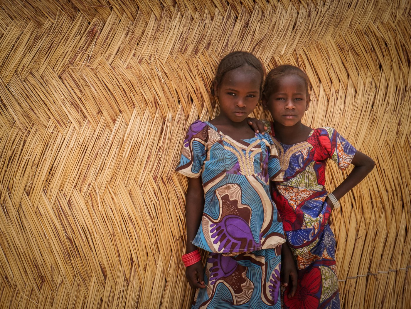 Two sisters standing in front of a transitional shelter built by NRC at Fariya camp for internally displaced persons in Maiduguri, northeast Nigeria. When this informal camp was established in 2014, there were only makeshift tents made out of tarp, straw, debris of wood and any other scrapped materials that displaced families could find. Last year, NRC started the construction of transitional shelters in the camp offering families with more sustainable housing.
Photo: Hajer Naili/NRC