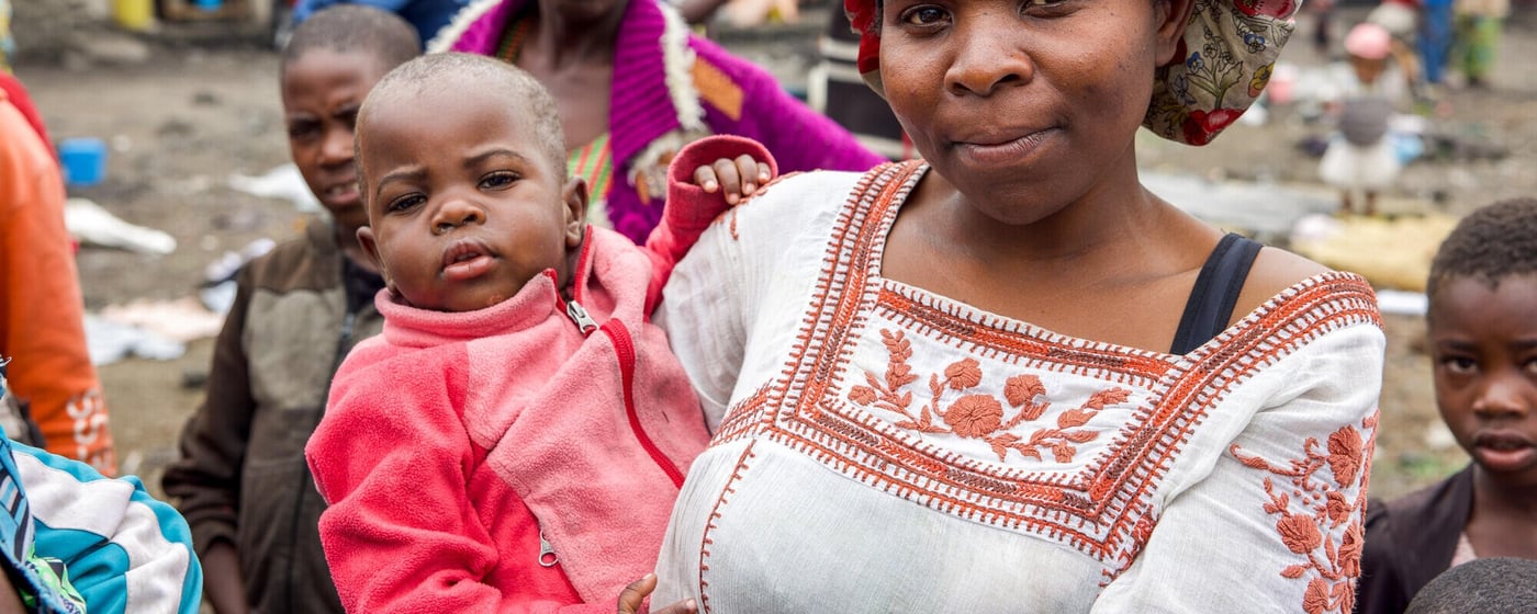 En kvinna håller sitt barn i ett tillfälligt läger för människor som tvingats lämna sina hem på grund av våld i östra Kongo-Kinshasa.