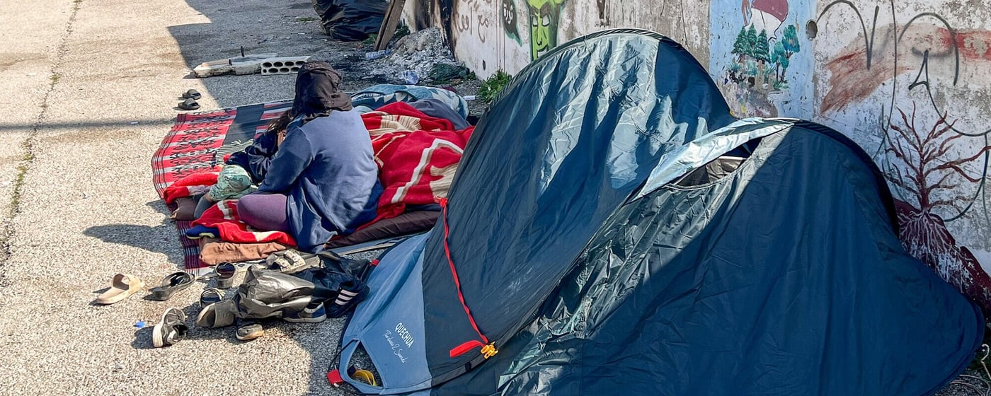 Fördrivna familjer sitter och vilar bredvid sina tillhörigheter utanför små tält längs en gata i Beirut.