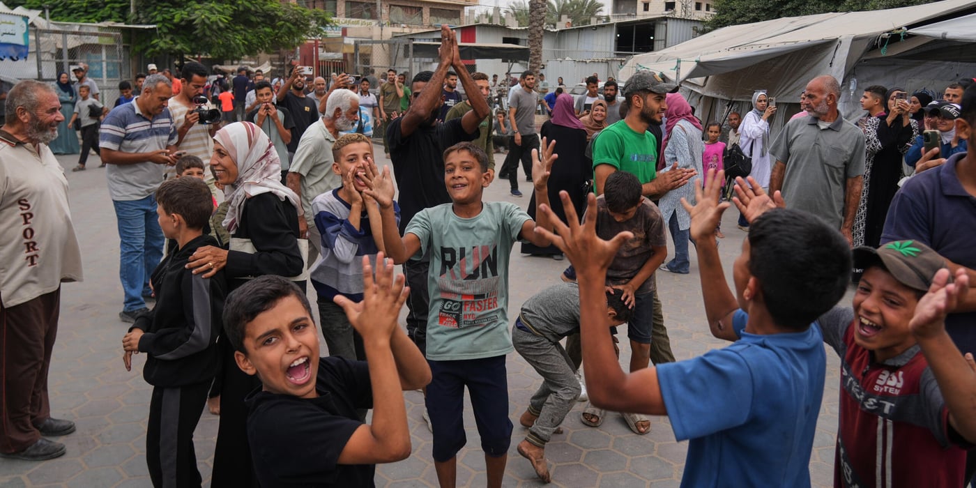 Palestinier firar efter beskedet att Israel och Hamas har enats om det första steget i en fredsplan för att pausa striderna, utanför al-Aqsa-sjukhuset i Deir al-Balah i centrala Gazaremsan, torsdagen den 9 oktober 2025. Foto: Abdel Kareem Hana/AP/NTB
