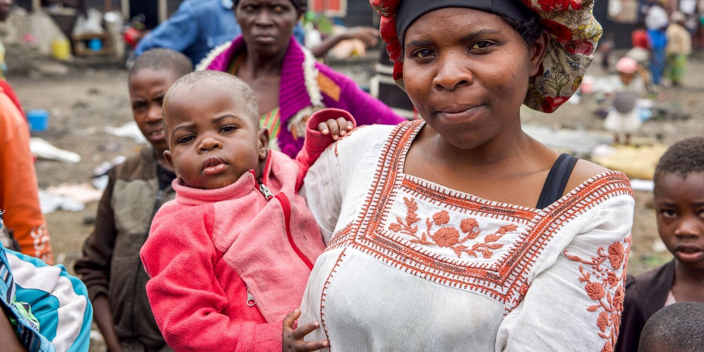 En kvinna håller sitt barn i ett tillfälligt läger för människor som tvingats lämna sina hem på grund av våld i östra Kongo-Kinshasa.