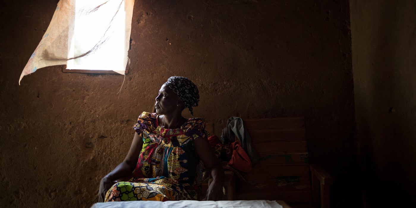 Marguerite Nguena poses in the house she occupies.
Marguerite Nguena, 62, widow, lives with some of her seven children and some of her grandchildren.
"On December 5, 2013, I fled to the Mpoko displaced site with my husband, children and grandchildren. A few months later my husband took a stray bullet at the site. It killed him. After that, we went to a cousin's house next door to the Combattants neighborhood. We lived a year like this for 14 people in the house. And then my cousin's wife chased us away."
"Then I came back to Bazanga. I live in the house of a Muslim who fled the neighborhood. He wants to put his house back on rent, but I can't afford to pay the rent. He gave me six months to find a solution. If I don't find a solution, I will have to go back to my native village in Bossembélé."
"I don't have a job. Sometimes members of my church give me something to help me. We are in a state of insecurity. Again tonight, around 9:00 p. m. we heard cracklings of weapons."
Since 2013, numerous outbreaks of community violence have provoked fighting in Bangui, the capital of the Central African Republic. In the most exposed neighbourhoods, the population was forced to flee to seek refuge with their families or in the various IDP sites of the city. Today all these sites have been closed and the inhabitants are returning home. The NRC meets these returnees to raise awareness of land rights and help them resolve conflicts related to illegal house occupations and evictions.
Photo credit: NRC/Alexis Huguet
Date: August 25, 2017