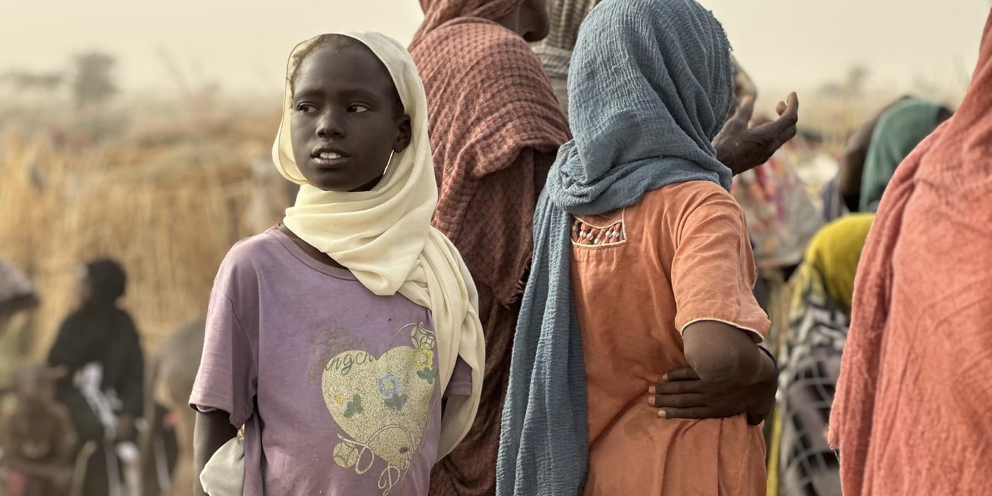 Fördrivna barn och vuxna samlas i ett tillfälligt bosättningsområde efter att ha tvingats fly undan våld och osäkerhet.
