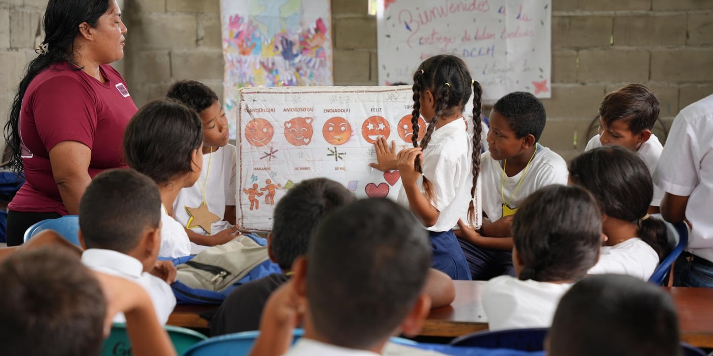 Lärare undervisar i ett klassrum framför en whiteboard.