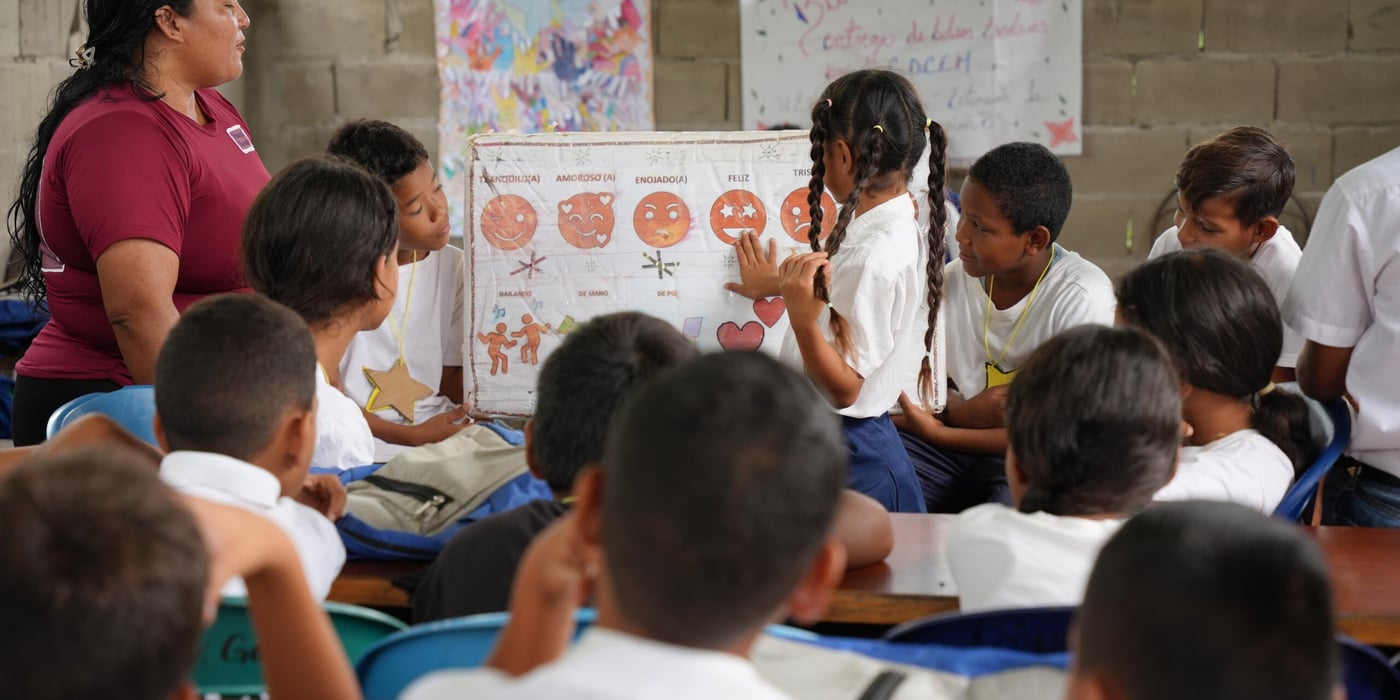 Lärare undervisar i ett klassrum framför en whiteboard.