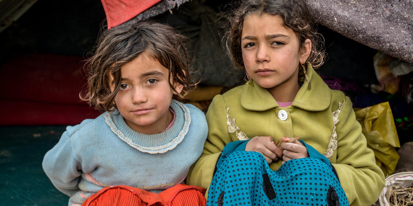 From right to left: Naseema, 9, Gul Ghotay's second daughter and Naseema's friend Latifa (in blue) inside their makeshift home in Feristan IDP settlement. PHoto: NRC/Enayatullah Azad