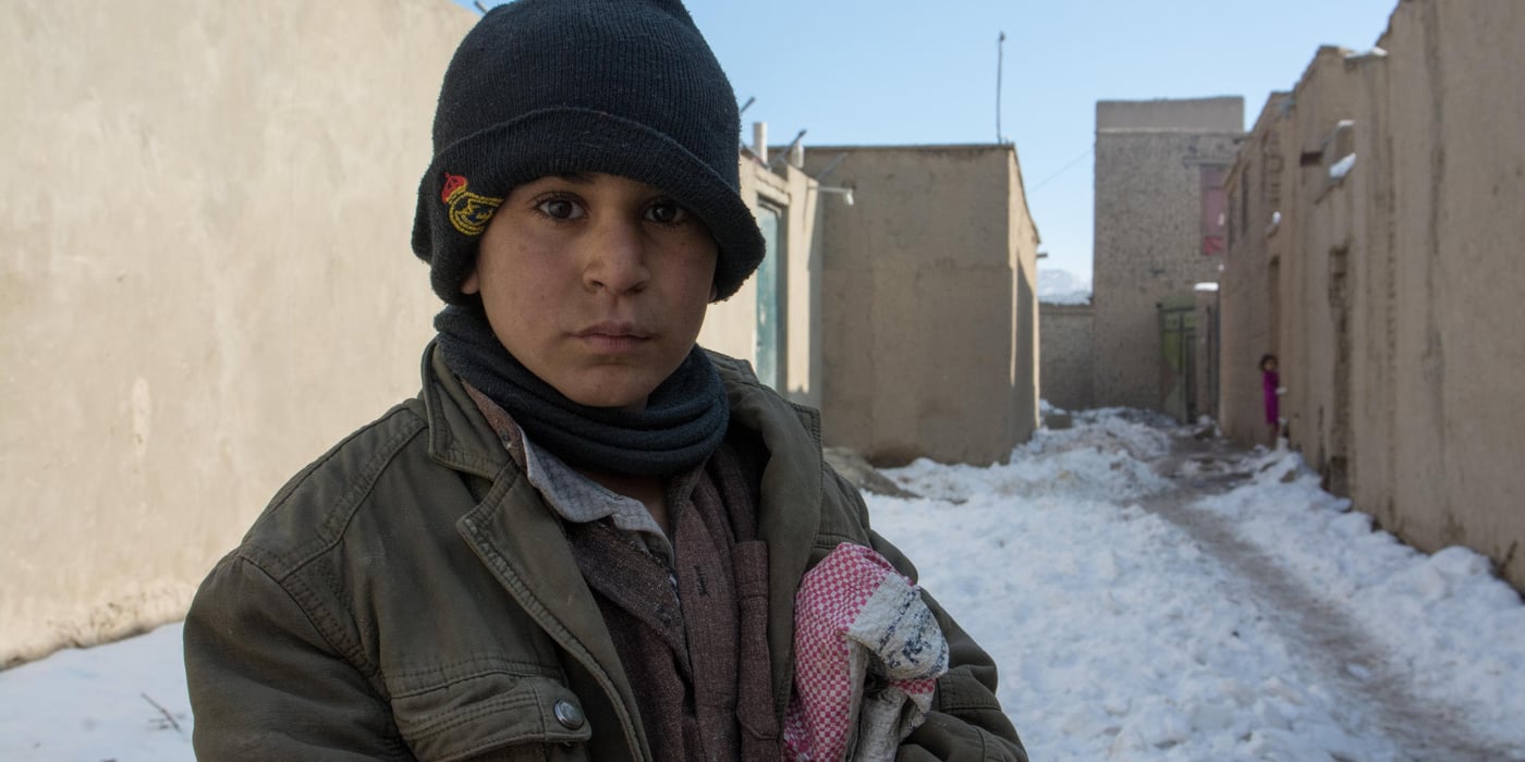 What is your name?
Akhtar Mohammad.
How old are you? 
I don’t know 
Are you going to school? 
No.
Then what are you doing during the day? 
I’m collecting scarps on the streets. 

Akhtar a thirteen-years-old who deals with paper, notebooks and books all the day do not attend the class. Akhtar is an IDP child living in an IDP settlement in west Kabul. He and has family has fled conflict some two and half years ago from Kunduz province. Akhtar has five siblings. He and his father works on the streets collecting scraps. He usually collects Pepsi cans and papers. He sells the cans and brings the paper home to burn to make the house warm and also, to cook food. 
As the Afghan children are very delightful for the first winter snowfall on Friday and are playing and making snowballs; Akhtar has left the home with a bag to collect scraps. Akhtar and has family spent last winter in makeshift tents. NRC with generous support of DANIDA upgraded their shelter to fight against the freezing temperature this winter. Photo: NRC/Enayatullah AzaD