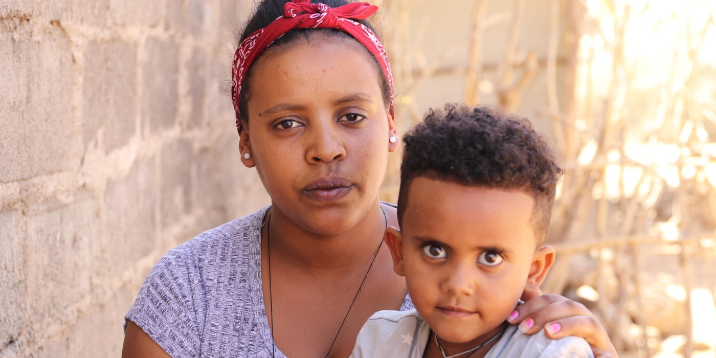 Eden didn’t tell her parents she was fleeing Eritrea and leaving them. She has dreams of reaching Europe and being reunited with her brother in Germany, but he doesn’t want his little sister to take the dangerous journey.
"I had to leave Eritrea. Life there is really hard."
We first meet the twenty-year-old in a refugee camp in northern Ethiopia. It’s dry season, and the temperature is rising quickly during the morning hours, reaching almost 40 degrees. The ground is dusty and the trees don’t have enough green leaves to protect us from the sun.
Eden greets us outside the bright turquoise-painted house as we arrive, asking us to come inside. "I’ve lived here for a little more than a year now," she says.
She didn’t plan to stay that long.
"I want to go to Sudan, then Libya and further on to Europe," she explains. And yes, she is aware that it is a dangerous journey. She has friends who have taken the same route, some of whom made it to Europe. Others didn’t complete the journey.
Keeping her parents in the dark
In 2017, more than 25,000 Eritreans fled across the southern border of their country to Ethiopia. Most of them are youth and minors, and many fled alone. Most cite Eritrea’s mandatory national service, which is compulsory for citizens from the age of 18, as the main reason for leaving the country.
Four years ago, Eden’s 27-year-old brother made it to Germany. He took the long, dangerous journey through Sudan and Libya and across the sea to Europe. In November 2016, Eden decided to do the same. She said nothing to her family.
"If I had told them, I’m certain they would have stopped me."
First, she went to her grandfather’s place to hide from the military. While she was there, she asked her aunt to send her some money, which she then paid to a smuggler. On the day she left, she saw her father in the street. She managed to hide from him.
"I regret that I didn’t have the chance to say goodbye to him," she says, tears in her eyes. It was not an easy decision to leave her mother, father and siblings, but Eden felt she had no other choice.
As I see it, I have two options in life: to succeed or to fail. I have heard it’s very difficult, but as long as going through Sudan and Libya is the only way to reach Europe, that’s what I want to do."
Eden, 20.
Hid from the military
Along with a group of 16 others, she embarked on the journey from Asmara, the Eritrean capital. They walked for five days before the military showed up and started shooting, forcing them to hide for two days with no food or water. The entire time, Eden was afraid they would get caught. She knew there are penalties for evading or deserting the service. In the end, they decided to go back to Asmara. There, the smuggler called, urging them to continue the journey. Eden, along with four others from the original group, decided to try a second time, and about a week later, they arrived at the Ethiopian border.
"I miss my family. They didn’t support my wish to leave and my aunt considers me a thief. The only family I have now are the girls I stay with."
In the camp, Eden shares a small house with five young women her age. They didn’t know each other before they arrived but have become good friends. All of them left their families and fled their home country in similar fashion. Eden has not been in touch with her parents since she left, but when the internet works, she chats with her sister on Facebook. Earlier this week, she called her brother in Germany.
"He doesn’t want me to leave for Europe and keeps telling me to stay in the camp because there will be opportunities for me in Ethiopia."
Will either fail or succeed
Eden has made up her mind.
"As I see it, I have two options in life: to succeed or to fail. I have heard it’s very difficult, but as long as going through Sudan and Libya is the only way to reach Europe, that’s what I want to do."
Facts
Eden is not alone. Most of the Eritrean refugees leave the camps within the first year of their arrival. Many attempt the journey to Europe, often with assistance of smugglers and at great risk to their lives.
"The only reason I’m still here is that it has become more difficult to go. My plan is to go, and I will take the same route as everybody else. I don’t know when. It could be tomorrow, the day after, in a month or a year, but as soon as the sea-border is open, I will go."
Big plans
Eden spends her time in the camp planning for the future. Along with her roommate Winta, 23, she goes to cooking classes at the Norwegian Refugee Council’s (NRC) youth education centre in the camp.
"I am very happy that I have not wasted my year in the camp. Unlike others, who just sit around doing nothing, I have studied and worked hard," she says with a smile.
The next day, she will sit the cooking exam that will give her the Ethiopian government’s official certificate. She is not nervous.
“I am feeling fine. I am well prepared, and our teachers have been very good, so I hope I will pass.”
On the day of her cooking exam, we meet her at the youth education centre. She is wearing her cooking clothes and hat and looks ready.
During the six-month course, she has learned how to cook various meals, make sauces and bake bread. She has followed lessons in proper kitchen hygiene, learned how to make the table and serve customers. On examination day, she is showing her skills to the examination proctor from the Ethiopian government.
An hour later, she has a big smile on her face. She passed the exam.
“I have got a lot of plans,” she says, serving us freshly made club sandwiches, potato bread and salad. “I would like to work in the restaurant of a big hotel, preferably in Europe. Then, with time, I want to open my own restaurant. I will call it Asmara.” Photo: Ingrid Prestetun/NRC