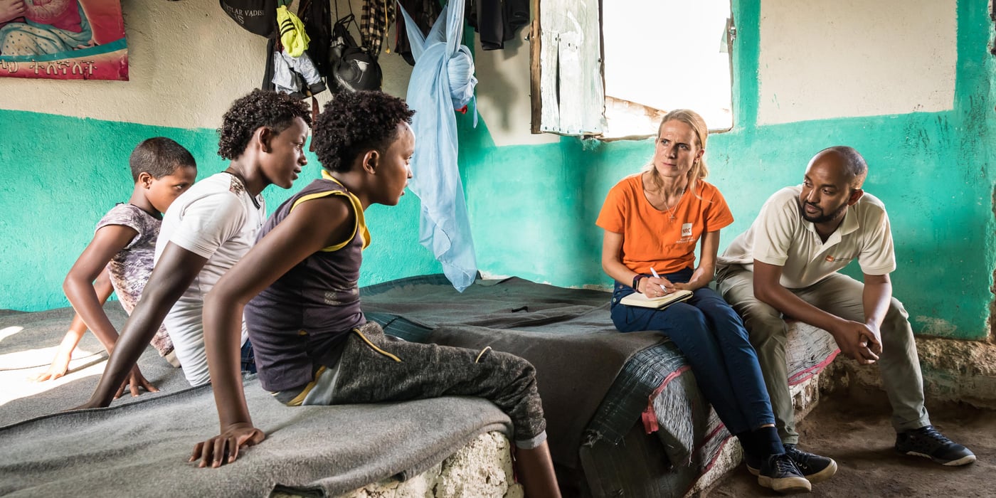 Meable, 12 years old, Meyhaw, 15 and Awet, 14 live together in a house in Hitsat refugee camp just outside Shire, a district in northern Ethiopia. The camp houses about 10,000 refugees from Eritrea. Most of them are minors, and about one in ten have fled alone. 

Interviewed by Head of media and communication Tuva Raanes Bogsnes.

The waiting room

Inside two small houses in a refugee camp in northern Ethiopia, seven girls and three boys wait for the Crown Prince Couple of Norway to visit.  All the children fled across the border from Eritrea, alone. “Off course we miss our families, but we cannot return now,” the children say.

It’s lunchtime and 15-year-old Furtuna sits next to a pot, stirring with all the strength she has. A sauce of tomatoes, paprika and onion simmer inside. She is preparing food together with the eldest children, while the youngest girls have other tasks, like fetching bread or cleaning. The seven girls, who live in the house together, didn’t know each other before they came to Hitsats refugee camp. 

“Now, we’re like sisters,” Winta says. For almost two years, the 16-year-old has stayed in the children’s collective run by the Norwegian Refugee Council (NRC). “Our friendship means a lot now.” 

The room is no larger than 20 square metres, yet the seven girls use it as a bedroom, a kitchen and a living room. They also share the three beds. On the left side of the house lives an adult who is responsible for the girls, watching out for them and helping them when needed. On the right side of the house live six boys who also fled Eritrea to Ethiopia, alone. 

As one of the eldest, Winta explains why they left their home country: “We’re all afraid to end up in the military and to lose the opportunity to get education. In the military you never finish and you have no choice. They come to get you, perhaps in the middle of the night. That’s why many of us had to leave.”

The girls crossed the border to Ethiopia on foot, all alone. “We heard people were shot on the way. In school, they told us that many girls were raped while trying to get away,” says Winta. The other girls nod their heads in affirmation. 

In the camp, the children attend school and get food. The girls are happy to live safely in the neighbouring country. “The very best is that we don’t have to be afraid anymore. And we have the opportunity to go to school and learn,” Winta says. 

The next door boys are 12, 14 and 15 years old. They have the same stories as the girls – grateful to be in safety, to escape the endless military service and to have the opportunity to go to school. 
“The education helps us grow and to make us stronger,” says 15-year-old Meyhaw. He came to the camp five months ago. 

When you ask the children if they have relatives in Europe, they all nod their heads. Uncles in Sweden and brothers in Germany. In the boys’ house, they plan to go further abroad. 

“We’re thinking that we have to travel to Sudan, Libya and then Europe. But for now it’s too strict, so in the meantime we’re happy to get more of an education,” says Meyhaw. 

The girls are not quite convinced as the boys about leaving Ethiopia. “I have a brother who left with a cousin, but only my brother made it over the sea,” says 15-year-old Weyni. “There are days when all I want is to travel, but then I feel it’s hopeless. We know how dangerous it is.”  

For now, the children want to stay in the children’s collective. The boys love their soccer practice and some of the girls have recently joined a drama group. If they were to wish for something better in life, they would wish for electricity to do homework. They would wish for some new clothes and maybe a cinema, so they could watch movies and forget about reality for a while. 

Photo: Beate Simarud/NRC Facts and figures:

Eritreans are the third largest group of refugees living in Ethiopia, with 37,321 refugees currently registered in refugee camps in the Shire area camps. 

Currently there are 163,281 Eritrean refugees in Ethiopia.

It is estimated that nearly 40 per cent of Eritrean refugees leave the camps within the first three months of arrival, and 80 per cent leave within the first year, with significant numbers of the population departing irregularly from Ethiopia to third countries – often with the assistance of smugglers and at great risk to their lives. 

The population in the Shire camps is unique, with a large number of children below the age of 18 and unaccompanied children. 

As of June 2017, 72 per cent of the refugees living in Shire were under the age of 18, including 4,725 unaccompanied and separated children, representing approximately 11.5 per cent of the total refugee population. 

Unaccompanied and separated children live in a variety of care arrangements, including community care, foster care, or family-based care.