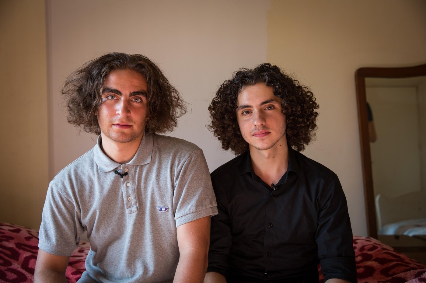 Marlon and Osama at home in the flat where Osama's parents and siblings live utside of Beirut. 

When Osama was 15 years old he fled from the war in Syria together with his parents and four siblings. Now, five years later, he is 20 years old and has just seen his dreams for the future shattered yet another time. 

Osama grew up in the outskirts of the Syrian capital, Damascus. A modern, vibrant and stable city until the war broke out in 2011. He lived a normal life. Went to school. “My country was a nice place to live in. I reached grade 10 in this school. I loved being there,” says Osama. “We lived in an area like Beirut. There were buildings and streets, it was not a village. Our flat was on the ground floor, with three rooms and two gardens. It's awful, because when I was a child, I had a dream to build my future life in that area. I wanted to become a doctor, and open a clinic in my house. My father and mother used to tell us, my siblings and I, that we will transform the house into a medical centre, each room for each one of you.  But we cannot do it now. So, I should find alternative solutions, alternative dreams.”
				
“Maybe you heard about the chemical attacks in 2013? We were near the spot where the chemical attacks happened. After the attacks, president Obama said that he will attack Syria or some points in Syria, so we left. We decided to leave Syria for 3 months, we hoped that the condition in our country would become safer. But the conditions stayed the same, not stable.”
			
“Maybe I should start with the positive things. I am a student in the university. I got a scholarship here. My family is with me. I am sure this is a good thing. My friends' families stayed in Syria.” The dream of becoming a doctor and open a clinic is put on hold for Osama. “Now, I am a computer science student, maybe I will find myself there. I hope I can open a mobile school to teach people.” To be closer to university, Osama lives in a shared flat with nine other Syrian youths in central Beirut. They are close knit group who support each other through thick and thin. His family rents an apartment outside Beirut, and Osama spends his weekends there with them. 

For a Syrian refugee living in Lebanon, there are many limitations. Osama and his older sister are the breadwinners of the family and feel the big burden on their young shoulders. “Even if you found an opportunity to complete your education, and you have a master degree or a PHD for example to become a doctor, you are not allowed to work. Living here is very expensive, so you need a lot of money. My biggest challenge is that the economic situation is so bad, not for me, but for all the Syrian families.”, says Osama. 

“Maybe the bad things here, as a Syrian guy in Lebanon, there are a lot of regulations that restrict my life, which make me not like a normal guy. Right now, I don’t have an official residency, so I cannot go to every place I want. I entered Lebanon legally, but you have to pay $200 per year for each person above 15 years old for a residency permit. So, if your family consists of seven members like ours, you have to pay $1000 yearly. I didn't pay, so they took my passport and now I cannot move or leave this country.” 

Osama and his family have tried to find another way to build their future elsewhere. They applied for resettlement. After a long process, including two interviews, Osama got the phone call. They were rejected. “I feel I am in a big jail. Like an animal in a zoo,” says Osama with tears in his eyes.  The rejection was a big blow for Osama and his dreams for the future for himself and his family. “I cannot go back to Syria, and I cannot leave this country. So, I will try to live here.” Osama tries to think positive. “I consider Lebanon my second country, I love Lebanon so I want to serve this country. I want to build my family here. When I came here they said welcome, so I owe them one.”

Photo: Ingebjørg Kårstad/NRC.