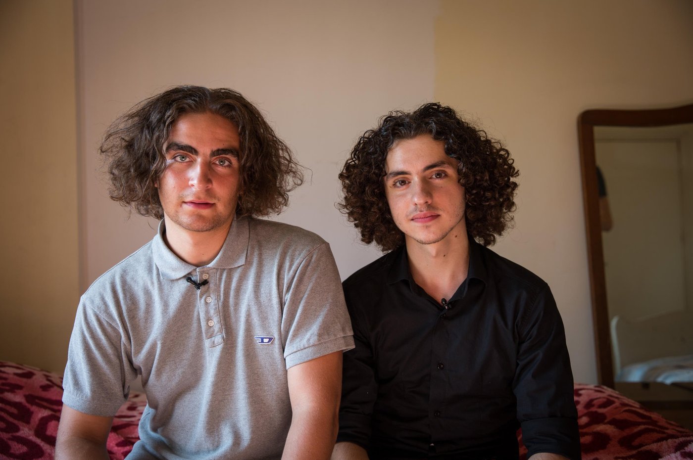 Marlon and Osama at home in the flat where Osama's parents and siblings live utside of Beirut.
When Osama was 15 years old he fled from the war in Syria together with his parents and four siblings. Now, five years later, he is 20 years old and has just seen his dreams for the future shattered yet another time.
Osama grew up in the outskirts of the Syrian capital, Damascus. A modern, vibrant and stable city until the war broke out in 2011. He lived a normal life. Went to school. “My country was a nice place to live in. I reached grade 10 in this school. I loved being there,” says Osama. “We lived in an area like Beirut. There were buildings and streets, it was not a village. Our flat was on the ground floor, with three rooms and two gardens. It's awful, because when I was a child, I had a dream to build my future life in that area. I wanted to become a doctor, and open a clinic in my house. My father and mother used to tell us, my siblings and I, that we will transform the house into a medical centre, each room for each one of you. But we cannot do it now. So, I should find alternative solutions, alternative dreams.”
“Maybe you heard about the chemical attacks in 2013? We were near the spot where the chemical attacks happened. After the attacks, president Obama said that he will attack Syria or some points in Syria, so we left. We decided to leave Syria for 3 months, we hoped that the condition in our country would become safer. But the conditions stayed the same, not stable.”
“Maybe I should start with the positive things. I am a student in the university. I got a scholarship here. My family is with me. I am sure this is a good thing. My friends' families stayed in Syria.” The dream of becoming a doctor and open a clinic is put on hold for Osama. “Now, I am a computer science student, maybe I will find myself there. I hope I can open a mobile school to teach people.” To be closer to university, Osama lives in a shared flat with nine other Syrian youths in central Beirut. They are close knit group who support each other through thick and thin. His family rents an apartment outside Beirut, and Osama spends his weekends there with them.
For a Syrian refugee living in Lebanon, there are many limitations. Osama and his older sister are the breadwinners of the family and feel the big burden on their young shoulders. “Even if you found an opportunity to complete your education, and you have a master degree or a PHD for example to become a doctor, you are not allowed to work. Living here is very expensive, so you need a lot of money. My biggest challenge is that the economic situation is so bad, not for me, but for all the Syrian families.”, says Osama.
“Maybe the bad things here, as a Syrian guy in Lebanon, there are a lot of regulations that restrict my life, which make me not like a normal guy. Right now, I don’t have an official residency, so I cannot go to every place I want. I entered Lebanon legally, but you have to pay $200 per year for each person above 15 years old for a residency permit. So, if your family consists of seven members like ours, you have to pay $1000 yearly. I didn't pay, so they took my passport and now I cannot move or leave this country.”
Osama and his family have tried to find another way to build their future elsewhere. They applied for resettlement. After a long process, including two interviews, Osama got the phone call. They were rejected. “I feel I am in a big jail. Like an animal in a zoo,” says Osama with tears in his eyes. The rejection was a big blow for Osama and his dreams for the future for himself and his family. “I cannot go back to Syria, and I cannot leave this country. So, I will try to live here.” Osama tries to think positive. “I consider Lebanon my second country, I love Lebanon so I want to serve this country. I want to build my family here. When I came here they said welcome, so I owe them one.”
Photo: Ingebjørg Kårstad/NRC.