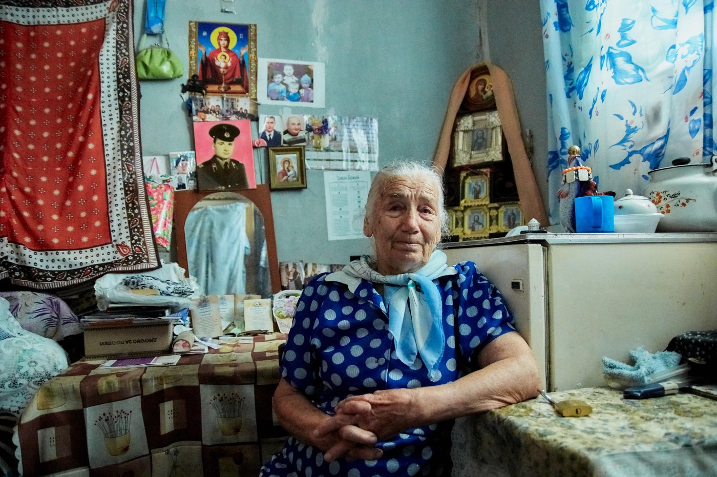 Oleksandra Belotserkovets, 86 years, from Marinka, lives alone in a small mouldy room in Kurakhove collective centre. Her home was destroyed, and humanitarian organisations still cannot assist her to rebuild her house, as it is in the red zone of contact line. Her husband died in 2010, two sons were killed - one in young age, second died as a result of shelling.
“On 11 of July my son Viktor called me, and suddenly I heard very loud sound of explosion, the lights went off. I was wandering what happened. My son cut off the phone and did not call me back. I was trying to reach him by landline and mobile phone. However, he did not answer. I had very bad feeling that something terrible happened. At night my daughter-in-law called me and told me to hide in the basement as a new shelling was about to start, when I asked her about my son, she bitterly cried and said that he was dead. My neighbour helped me to get to Viktor’s house and I saw him dead, I will never forget what I saw that day. We could hardly bury him, the shelling was very close”, recalls Oleksandra.
Oleksandra’s house was burnt completely, 20 days after Viktor’s death. Her son’s wife Svitlana brought her to nearby, but safer town of Kurakhove. Oleksandra did not want to be a burden and odd for Svitlana and grandchildren. She went to local administration; they provided her with small room in the collective centre.
Many times Oleksandra to local authorities with request to get accommodation, small house. She is worried that one day she will be evicted from the centre. As of now, her house cannot be restored, as it is in red zone. She is seeking assistance to receive small, but own house in safer place.
Photo: Dmytro Telushkin/the Norwegian Refugee Council