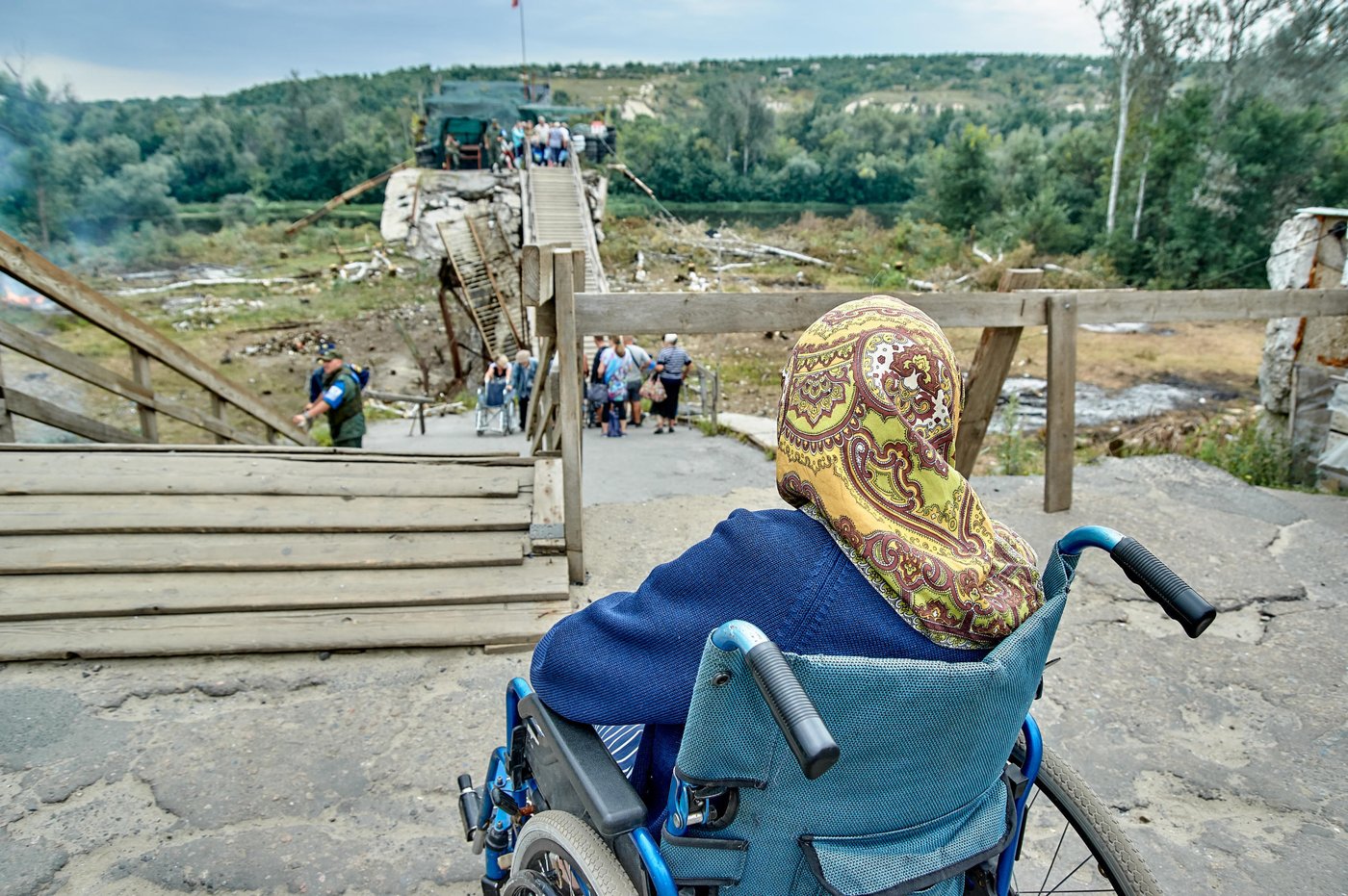 The protracted crisis in the Donbas region of Ukraine is well into its sixth year. The contact line continues to separate Government controlled area (GCA) and Non-Government controlled area (NGCA) of Donetsk and Luhansk regions. This separation isolates much of the population in GCA from important services and livelihood providers in urban centres in NGCA. Along the 427-kilometre contact line, there are five open exit-entry checkpoints (EECP) in Hnutove, Novotroitske, Marinka, Maiorsk and Stanytsia Luhanska, where internally displaced and conflict-affected people cross to visit relatives, buy food and other goods, receive social payments and check on their property.

Since the opening of these EECPs, the number of people crossing the contact line continues to grow. Every month, there are about 1,3 million people recorded crossing through all five of the EECPs. Long queues and correspondingly, long waiting times at checkpoints continue to be reported. During their journey to cross the contact line, very often people face difficult weather conditions and slow processing times. These civilians who cross the contact line have limited access to basic services such as drinking water, latrines, weather shelters, heating, and medical care.

Photo: Dmytro Tielushkin/The Norwegian Refugee Council (NRC)