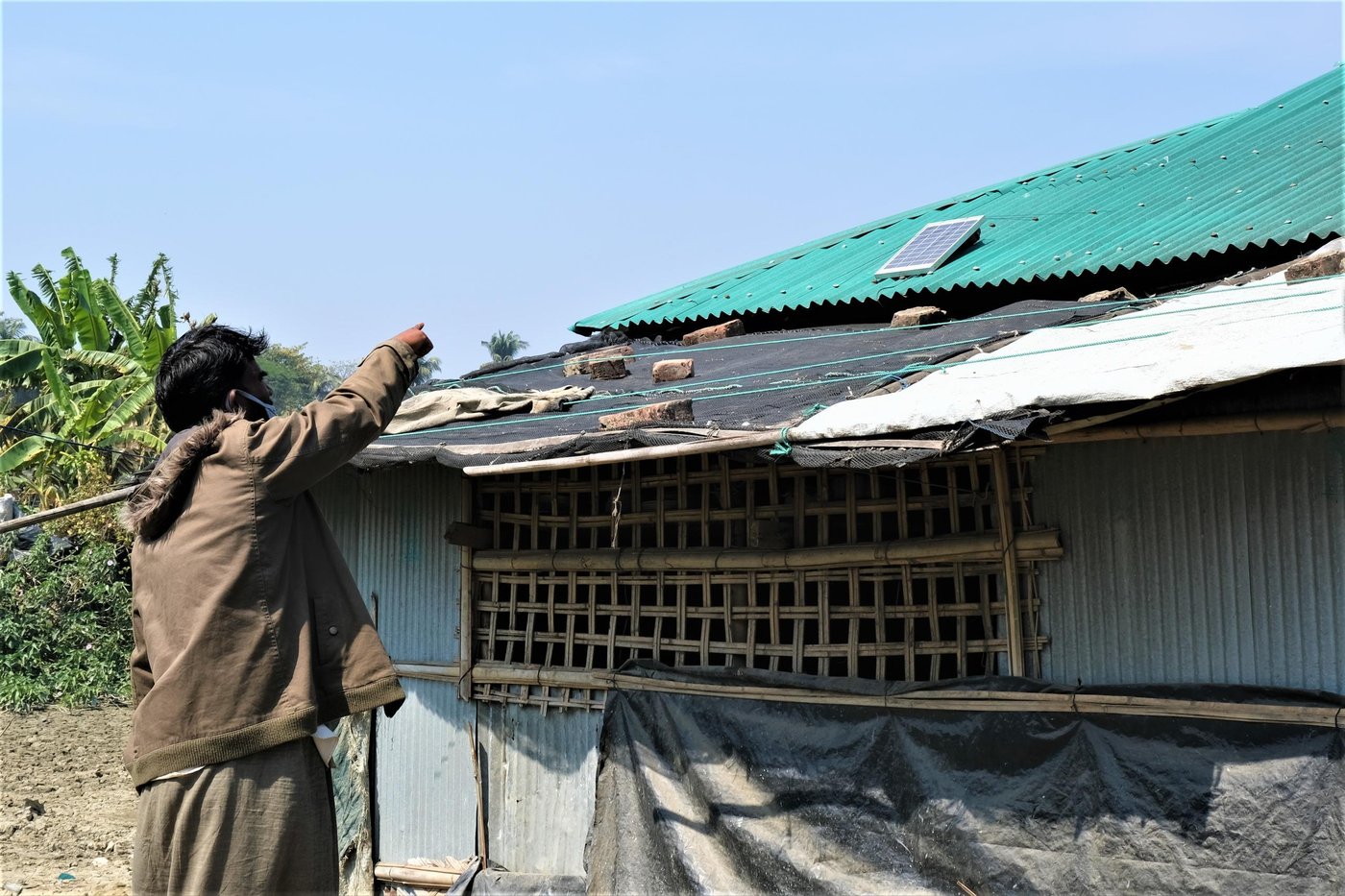 Habibullah shows us the solar panel on the roof of his house. Photo: Ayesha Nawshin/ NRC