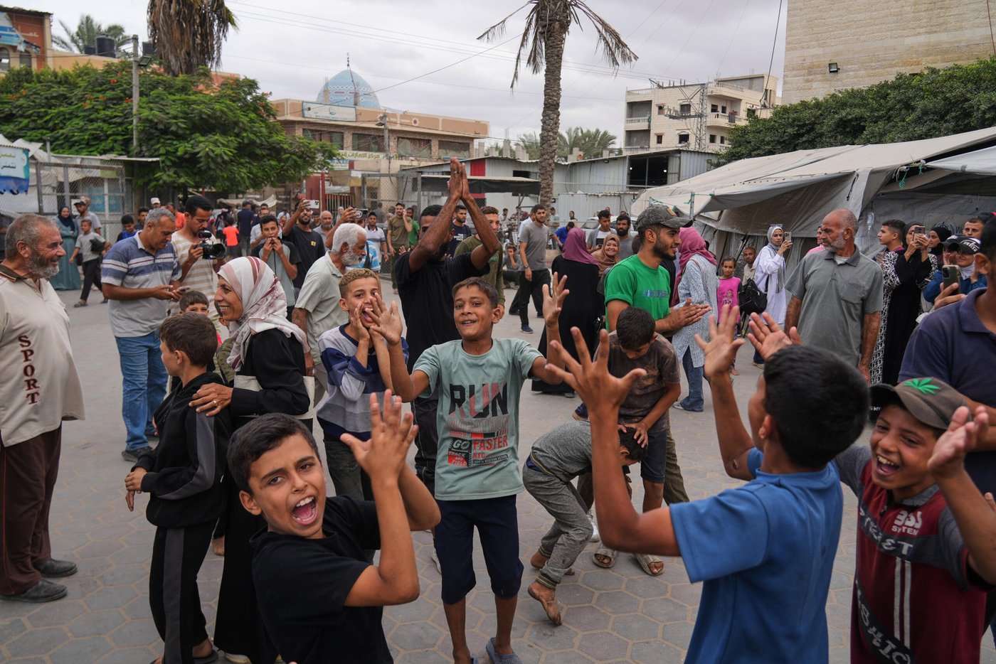 Palestinier firar efter beskedet att Israel och Hamas har enats om det första steget i en fredsplan för att pausa striderna, utanför al-Aqsa-sjukhuset i Deir al-Balah i centrala Gazaremsan, torsdagen den 9 oktober 2025. Foto: Abdel Kareem Hana/AP/NTB
