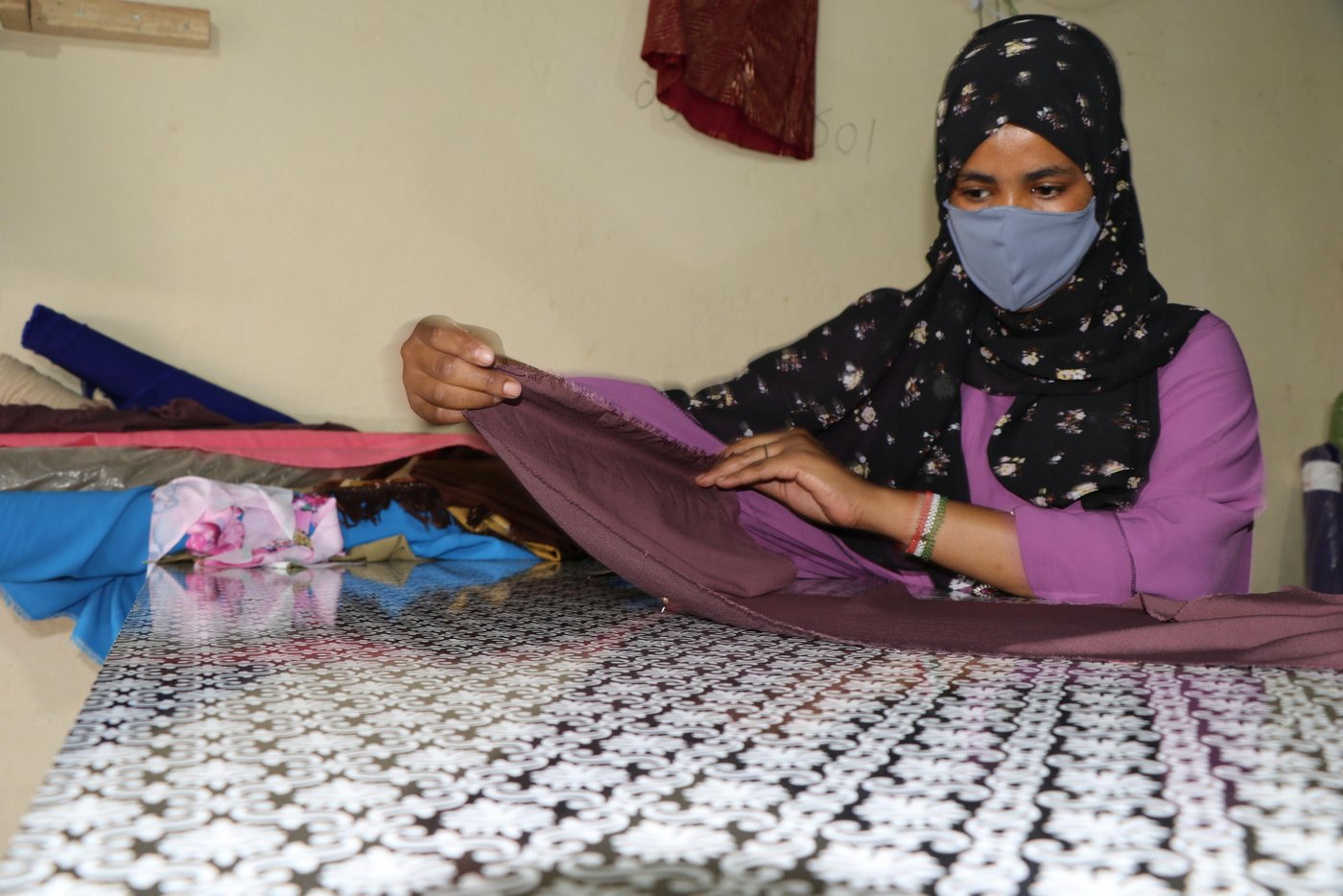 Hafsa is 22 years old young girl. She lives in Hargeisa with her family. Hafsa and her family have previously been displaced from Ethiopia and lived in Somaliland for so many years. She was one of the youths selected from the IDPs, refugees & asylum seekers project in Somaliland for a tailoring course, which is one of the vocational skill courses (Tailoring, Carpentry, Plumping, Electricity, Soap Production, Plastic Recycling, Painting & Decoration) under NRC’s livelihood project funded by UNHCR.

The project targets the vulnerable youths who have had limited access to training and employment opportunities, providing them the opportunity to attain well-planned vocational skills that enhance their ability to access and engage in livelihood opportunities. Hafsa is among young men and women who have already graduated from NRC’s vocational skills course. She is currently utilizing the previously attained skills in both employment and private engagement, enabling her to earn a decent income.

Hafsa says, “I am a tailor, and tailoring was always my favorite. I have got information that NRC and UNHCR are registering students for vocational skill courses. I went to the registration center. Fortunately, I was registered for the tailoring course. I was learning for around eight months. I really thank NRC and UNHCR for the tailoring course. After I had completed the course, I became one of five women who received investment money and sewing machines from NRC. We’ve established this tailoring shop. We sell and make clothes. After a short while, the COVID-19 pandemic has broken out in the country. Then we shifted our products into face mask production, which was very important and was actually a very good source of income for us. Students are now our main customers. We still produce other clothes for men and women, but face masks are our main products”.

Photo: Abdulkadir/NRC.