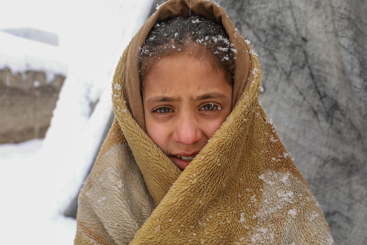“It was very cold inside and I thought if I go outside and walk I might feel warmer,” says Roqia, 11, standing outside her makeshift home in a snowy day in KABUL. 

Rogia doesn’t have enough clothes and proper slippers to keep her warm in a cold. Her family do not have sufficient firewood to keep the oven burning all the time and they only burn it once in a day and if the weather is freezing cold, they might burn it twice in a day. They burn plastics, cartons, packets and other waste materials they have collected during the summer season. 
“The house we have is out of plastic bags, blankets and mud. As soon as the oven dies the home gets cold,” she says. “It’s very cold during the night and we wakeup many times due to cold. Sometimes, I feel pain and burn in my feet, legs and back due to the cold.” 

Kabul gets very cold during the winter and last night only, the temperature dropped to -16 Celsius. Photo: Enayatullah Azad/ NRC