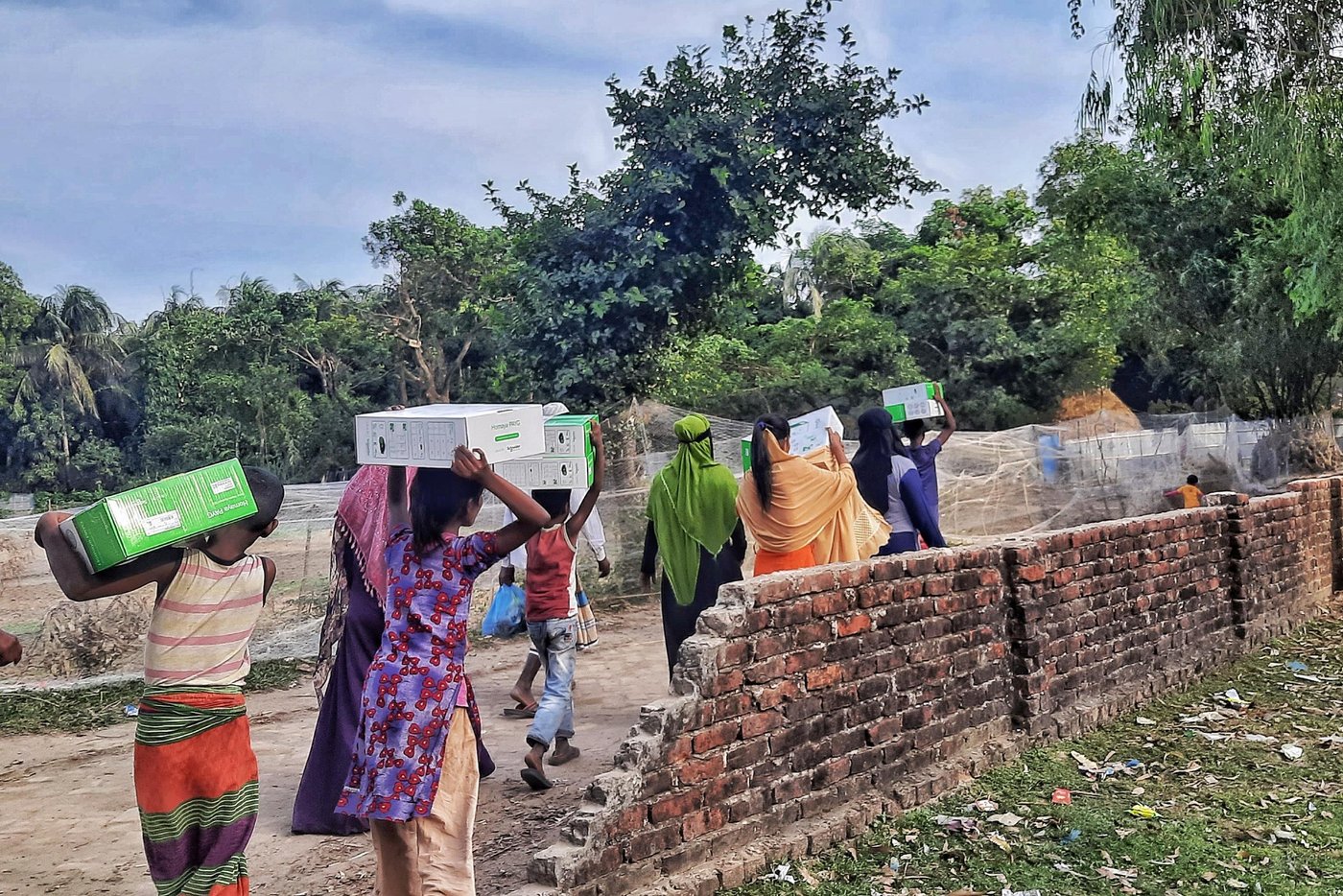 Piuli and her brother head home with solar panels. Photo: Ayesha Nawshin/ NRC