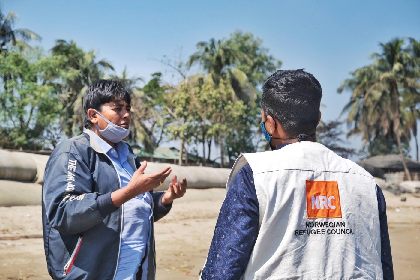 Shelter officer Akash in conversation with a resident of the island. Photo: Ayesha Nawshin/ NRC