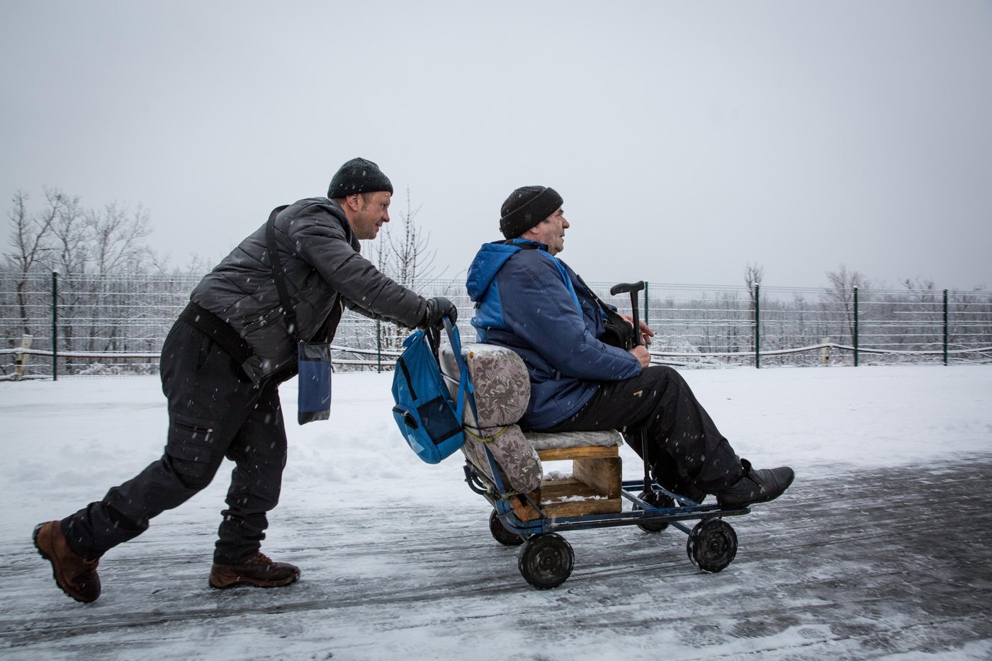 Every day thousands of people, many of them elderly, have to cross the checkpoint between government controlled and non-government-controlled areas of Ukraine at Stanytsia Luhanska. The bridge is destroyed, making it impossible for cars to pass, forcing people to walk for several kilometres through no man’s land and wait for 3-4 hours to pass each way. 

For those who are unable to make the walk, Slavik is ready to offer transport for a small fee. He works at EECP every day.
“I use this wheelchair to transfer elderly people. They have the same problems: a small pension, and expensive medicines. There are many people. The elderly people constantly complain about life. They have to show up in person every month in order to receive their pension", says Slavik. 

Photo: Ingebjørg Kårstad/Norwegian Refugee Council.