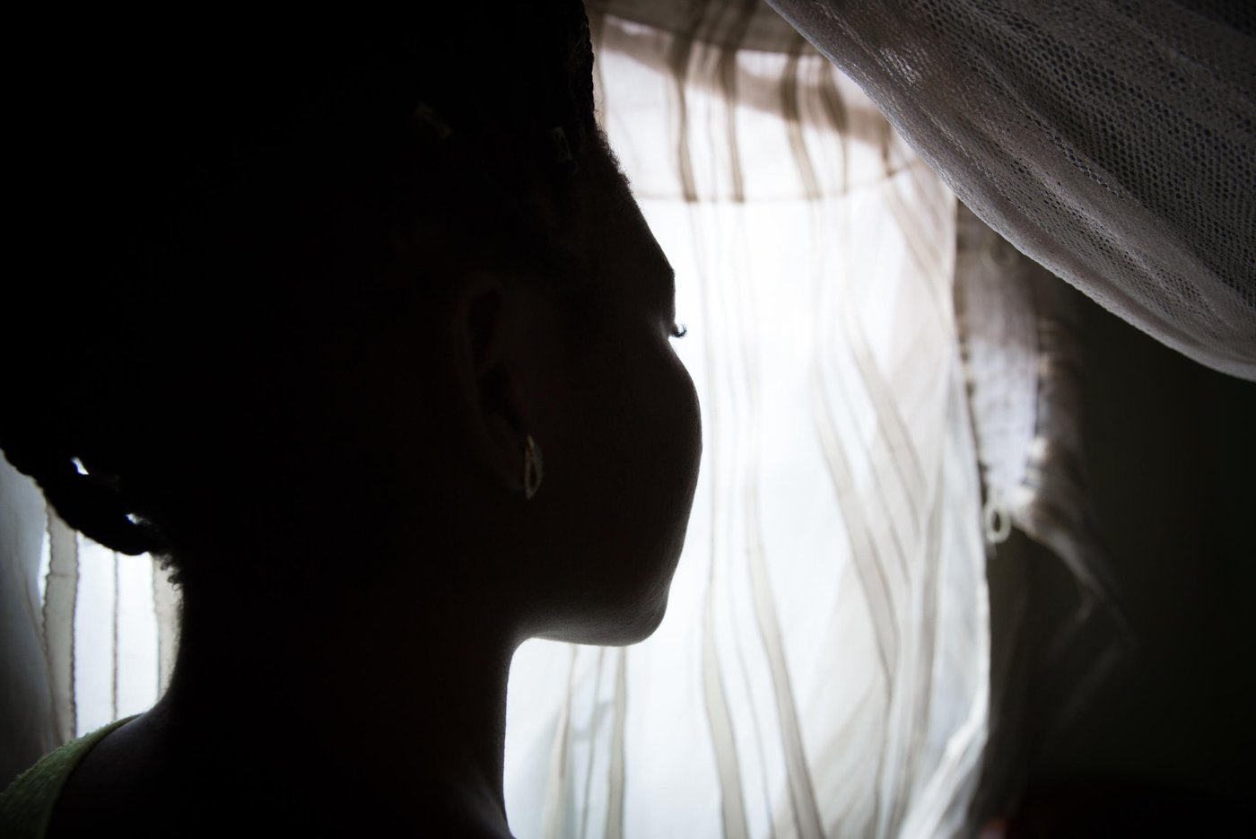 “When the crisis started I was going to school and at the same time helping my mom with her business. But, the fighting made things tough, business was tight, it was hard. I continued to go to school but the boys would come and meet us in school and beat us, then drive us away from school and force us to go back to the house. I have been beaten not once, not twice, but many times by those boys. They don’t want us to go to school, to make a future for ourselves and the society. If we go, they will beat you up and attack your family. So, I had to stop school because my family was really in danger,” Kelly, 21 years old, tells us when we meet her in November 2019.
The boys are what the armed separatists are called locally in the North West province. In 2016, as English-speaking lawyers, students and teachers began protesting what they saw as their cultural marginalisation and under-representation in the central government, the Government forces hit back with a hard hand. Several armed separatist groups emerged and eventually declared independence 1. October 2017. They called their new country Ambazonia.
Kelly lived in a big compound with her mom, dad, her siblings and extended family. Her parents ran a business and they had a farm.
“I had many people around me back then, but due to the crisis I have just a few left.”
On 11. February 2016, on the National Youth Day, clashes were intense in her village. The separatist did not recognise the youth day and put up the Ambazonia flag and the military retaliated.
“The military came to our compound. The gate was closed, but they climbed the fence and entered. They shot at anybody they saw, they never cared to know who was who, they were just shooting. My younger sister and myself were hiding under a bed. My uncle was also there and they just entered the room and shot him, thinking he was one of those boys. They shot him right in front of me and my sister. After that, there was no way we could sleep in the house, so we fled to the bush and slept there. In the morning we came back and took my uncle to the morgue to prepare the funeral. That’s when my mom and my dad decided that we should look for another way for me to go to school, because staying in the village, doing nothing, will not help me so it’s better I leave”.
Three months later, at the age of 18, Kelly left her home to go to Yaoundé. She found a place to live and started to work to save up money to continue her education and slowly built a new life for herself over the next three years. She felt safe again. Then, everything changed.
“I lost my dad 5. November. This month. I was not in the village when it happened, but they told me that he got up at night to ease himself. We do not have a toilet inside the compound so he had to go outside. Unfortunately, he was shot that night. He was taken to the hospital, but they could not save him.”
Every bullet victim is automatically investigated in the area, so the police came to talk to the family and her mother tried to answer all their questions. They found out it was the separatists, the boys, who had shot him. The situation was very intense in the village in that period. Kelly travelled from Yaoundé to the village for the funeral and then quickly returned to the capital due to the fighting.
Two days after her dad was killed, another crisis hit the family. Kelly’s older sister got kidnapped by the boys. The kidnappers asked for 2,5 million francs in ransom for the group. The family tried to raise 500 000 francs. Kelly gave 50 000 francs that she had managed to save during her time in Yaoundé. These were the money she would use for her school fees, but instead she had to spend them to pay for her dad’s funeral and now her sister’s kidnapping. Together, the family managed to find money and her sister was released.
“My sister was badly beaten. All her body; wounds, wounds, wounds. Fortunately, she was not raped, because those boys don’t sleep with girls who have their period. So, that was the only way she was saved from those guys. It was a miracle.”
After Kelly’s sister was released, she fled for safety to Bamenda, a bigger town in the area, where she is trying to attend some classes now and then. Kidnappings for ransom have become a regular thing in the province. Armed separatist groups have killed, tortured, assaulted, and kidnapped dozens of people, including students, teachers, clergy, and administrative and traditional authorities.
“I think the boys are kidnapping because they need money to purchase weapons,” Kelly states.
While her sister was still missing, Kelly received yet another call, this time from an unknown number, telling her she had to come back to the village for an emergency. They did not say what had happened, just that she had to come as fast as she could. Kelly was afraid she would lose her job if she left so soon after she had just been away for her dad’s funeral, but had to go and risk it.
“As I entered the compound, everyone was crying. The first thing I asked was ‘Where is my mom?’ Everybody was crying in silence. They asked me to sit down, but I said ‘No, I don’t want to sit down, I want to see my mom.’ Then they told me that my mom had passed away. I had a shock. The next thing I remember is waking up in the hospital. I spent two days there.”
“My mom was shot by those boys due to the investigation after my dad was killed. They know our house. They came inside our compound and asked for her. They shot her with four bullets to her body and left. No one else was shot. My mom was their main target. The boys were angry, because she spoke to the police. They don’t want us to have anything to do with the police.”
In less than a week, both Kelly’s parents had been killed. Her sister had been kidnapped.
She did not feel safe.
“At the funeral ground the boys kept looking at me. Just looking, looking, looking. I felt like I was going to be the next target. I had to leave the village, cause my life was in danger. It was a lot of gunshots. Everywhere. Everywhere! So, I managed to take the bush backroad and was lucky to find a taxi and I took it straight to Bamenda and then back here to Yaoundé. I told no one I was back. I just stayed inside for a week, mourning my mom and my dad. No school. No work. Just mourning them.”
In this period, she was also told to move out from the room she shared with a friend and this one’s sister who felt it had become too crowded. Now, Kelly needs to find a new place to rent, but with soaring housing process in the capital and her savings gone, it’s not an easy task.
“I lost my dad. I lost my mom. My sister was kidnapped. So, all my savings are gone. I’m back to square one. Even to have a meal per day is difficult. I tried to get an advance from my boss. I tried to borrow money from friends so I can afford to move into a new place.”
Kelly now works in a school canteen five days a week. She leaves the house at 5am, works, comes back at 2pm. Rests for a little while, then goes to evening school until 9pm. At night she can seldom afford to eat, so she goes to bed and gets up again at 2am to study when the house is quiet.
“I really need to go to school. Education is the key to life. Education is the highest thing. It was my parents’ dream for me, to go to school, to become something great in life that make you stand out in a population and talk like a woman. Even though they are no more, I have to work hard for myself and achieve my dreams.”
Kelly dreamt of becoming a lawyer, or a medical doctor, but now she is thinking accounting or management is more realistic. Or, play the American lottery and see if she can leave the country.
“Even though it’s hard to lose two parents at the same time, it’s nothing I can do. All the things they used to do for me, I now need to do alone. It’s hell. But, this is what my fate has decided for me. I just need to move on with life.”
Photo: Ingebjørg Kårstad/NRC