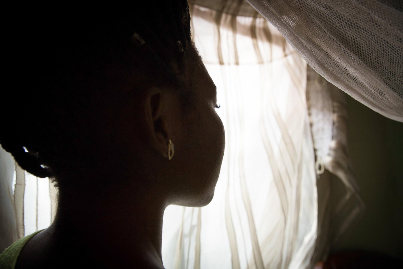 “When the crisis started I was going to school and at the same time helping my mom with her business. But, the fighting made things tough, business was tight, it was hard. I continued to go to school but the boys would come and meet us in school and beat us, then drive us away from school and force us to go back to the house. I have been beaten not once, not twice, but many times by those boys. They don’t want us to go to school, to make a future for ourselves and the society. If we go, they will beat you up and attack your family. So, I had to stop school because my family was really in danger,” Kelly, 21 years old, tells us when we meet her in November 2019.
The boys are what the armed separatists are called locally in the North West province. In 2016, as English-speaking lawyers, students and teachers began protesting what they saw as their cultural marginalisation and under-representation in the central government, the Government forces hit back with a hard hand. Several armed separatist groups emerged and eventually declared independence 1. October 2017. They called their new country Ambazonia.
Kelly lived in a big compound with her mom, dad, her siblings and extended family. Her parents ran a business and they had a farm.
“I had many people around me back then, but due to the crisis I have just a few left.”
On 11. February 2016, on the National Youth Day, clashes were intense in her village. The separatist did not recognise the youth day and put up the Ambazonia flag and the military retaliated.
“The military came to our compound. The gate was closed, but they climbed the fence and entered. They shot at anybody they saw, they never cared to know who was who, they were just shooting. My younger sister and myself were hiding under a bed. My uncle was also there and they just entered the room and shot him, thinking he was one of those boys. They shot him right in front of me and my sister. After that, there was no way we could sleep in the house, so we fled to the bush and slept there. In the morning we came back and took my uncle to the morgue to prepare the funeral. That’s when my mom and my dad decided that we should look for another way for me to go to school, because staying in the village, doing nothing, will not help me so it’s better I leave”.
Three months later, at the age of 18, Kelly left her home to go to Yaoundé. She found a place to live and started to work to save up money to continue her education and slowly built a new life for herself over the next three years. She felt safe again. Then, everything changed.
“I lost my dad 5. November. This month. I was not in the village when it happened, but they told me that he got up at night to ease himself. We do not have a toilet inside the compound so he had to go outside. Unfortunately, he was shot that night. He was taken to the hospital, but they could not save him.”
Every bullet victim is automatically investigated in the area, so the police came to talk to the family and her mother tried to answer all their questions. They found out it was the separatists, the boys, who had shot him. The situation was very intense in the village in that period. Kelly travelled from Yaoundé to the village for the funeral and then quickly returned to the capital due to the fighting.
Two days after her dad was killed, another crisis hit the family. Kelly’s older sister got kidnapped by the boys. The kidnappers asked for 2,5 million francs in ransom for the group. The family tried to raise 500 000 francs. Kelly gave 50 000 francs that she had managed to save during her time in Yaoundé. These were the money she would use for her school fees, but instead she had to spend them to pay for her dad’s funeral and now her sister’s kidnapping. Together, the family managed to find money and her sister was released.
“My sister was badly beaten. All her body; wounds, wounds, wounds. Fortunately, she was not raped, because those boys don’t sleep with girls who have their period. So, that was the only way she was saved from those guys. It was a miracle.”
After Kelly’s sister was released, she fled for safety to Bamenda, a bigger town in the area, where she is trying to attend some classes now and then. Kidnappings for ransom have become a regular thing in the province. Armed separatist groups have killed, tortured, assaulted, and kidnapped dozens of people, including students, teachers, clergy, and administrative and traditional authorities.
“I think the boys are kidnapping because they need money to purchase weapons,” Kelly states.
While her sister was still missing, Kelly received yet another call, this time from an unknown number, telling her she had to come back to the village for an emergency. They did not say what had happened, just that she had to come as fast as she could. Kelly was afraid she would lose her job if she left so soon after she had just been away for her dad’s funeral, but had to go and risk it.
“As I entered the compound, everyone was crying. The first thing I asked was ‘Where is my mom?’ Everybody was crying in silence. They asked me to sit down, but I said ‘No, I don’t want to sit down, I want to see my mom.’ Then they told me that my mom had passed away. I had a shock. The next thing I remember is waking up in the hospital. I spent two days there.”
“My mom was shot by those boys due to the investigation after my dad was killed. They know our house. They came inside our compound and asked for her. They shot her with four bullets to her body and left. No one else was shot. My mom was their main target. The boys were angry, because she spoke to the police. They don’t want us to have anything to do with the police.”
In less than a week, both Kelly’s parents had been killed. Her sister had been kidnapped.
She did not feel safe.
“At the funeral ground the boys kept looking at me. Just looking, looking, looking. I felt like I was going to be the next target. I had to leave the village, cause my life was in danger. It was a lot of gunshots. Everywhere. Everywhere! So, I managed to take the bush backroad and was lucky to find a taxi and I took it straight to Bamenda and then back here to Yaoundé. I told no one I was back. I just stayed inside for a week, mourning my mom and my dad. No school. No work. Just mourning them.”
In this period, she was also told to move out from the room she shared with a friend and this one’s sister who felt it had become too crowded. Now, Kelly needs to find a new place to rent, but with soaring housing process in the capital and her savings gone, it’s not an easy task.
“I lost my dad. I lost my mom. My sister was kidnapped. So, all my savings are gone. I’m back to square one. Even to have a meal per day is difficult. I tried to get an advance from my boss. I tried to borrow money from friends so I can afford to move into a new place.”
Kelly now works in a school canteen five days a week. She leaves the house at 5am, works, comes back at 2pm. Rests for a little while, then goes to evening school until 9pm. At night she can seldom afford to eat, so she goes to bed and gets up again at 2am to study when the house is quiet.
“I really need to go to school. Education is the key to life. Education is the highest thing. It was my parents’ dream for me, to go to school, to become something great in life that make you stand out in a population and talk like a woman. Even though they are no more, I have to work hard for myself and achieve my dreams.”
Kelly dreamt of becoming a lawyer, or a medical doctor, but now she is thinking accounting or management is more realistic. Or, play the American lottery and see if she can leave the country.
“Even though it’s hard to lose two parents at the same time, it’s nothing I can do. All the things they used to do for me, I now need to do alone. It’s hell. But, this is what my fate has decided for me. I just need to move on with life.”
Photo: Ingebjørg Kårstad/NRC