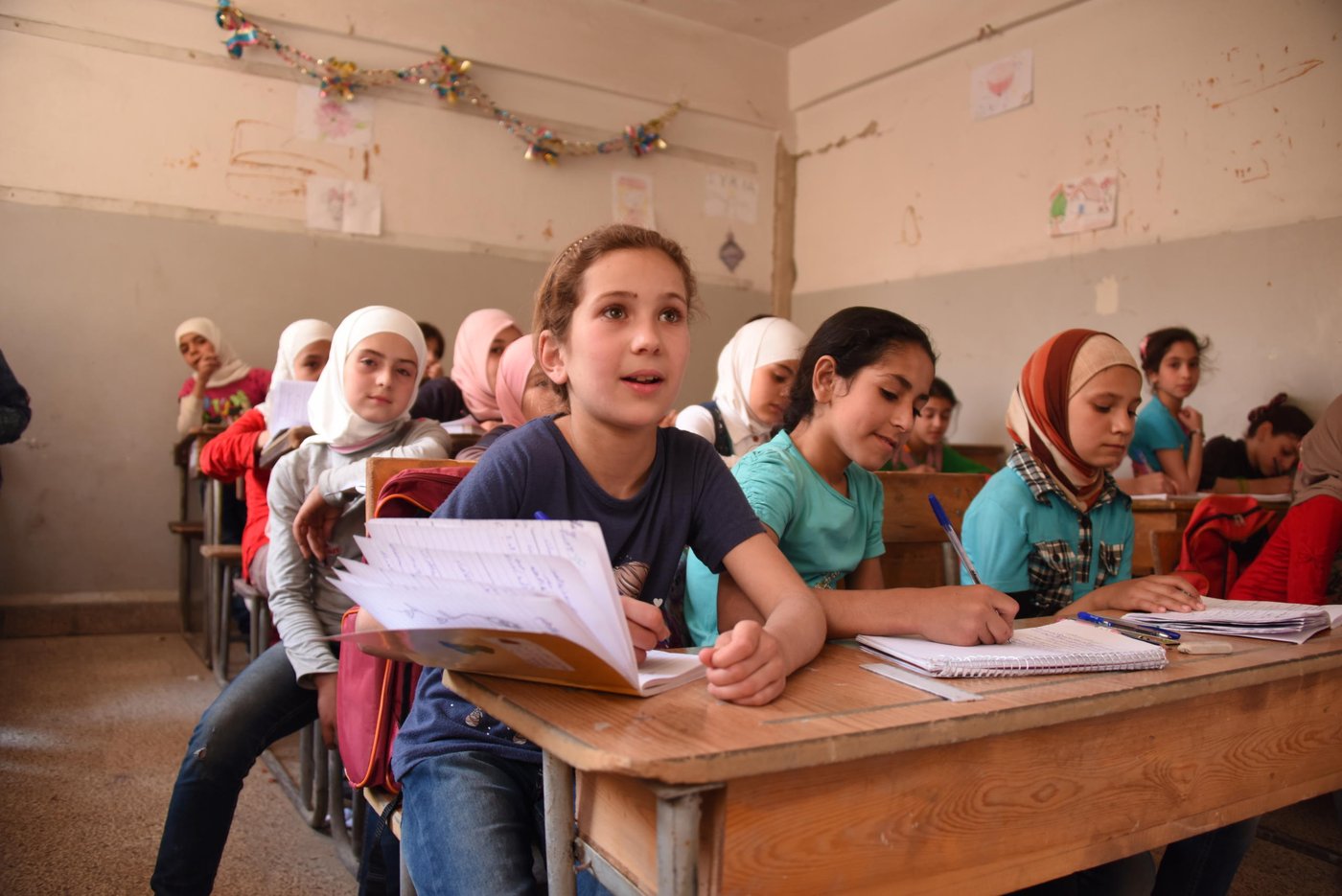 Raghad and Reem (left and centre), both 10, attend classes at Harasta School in Eastern Ghouta after months of living in basements and under siege.
Photo: Karl Schembri/NRC