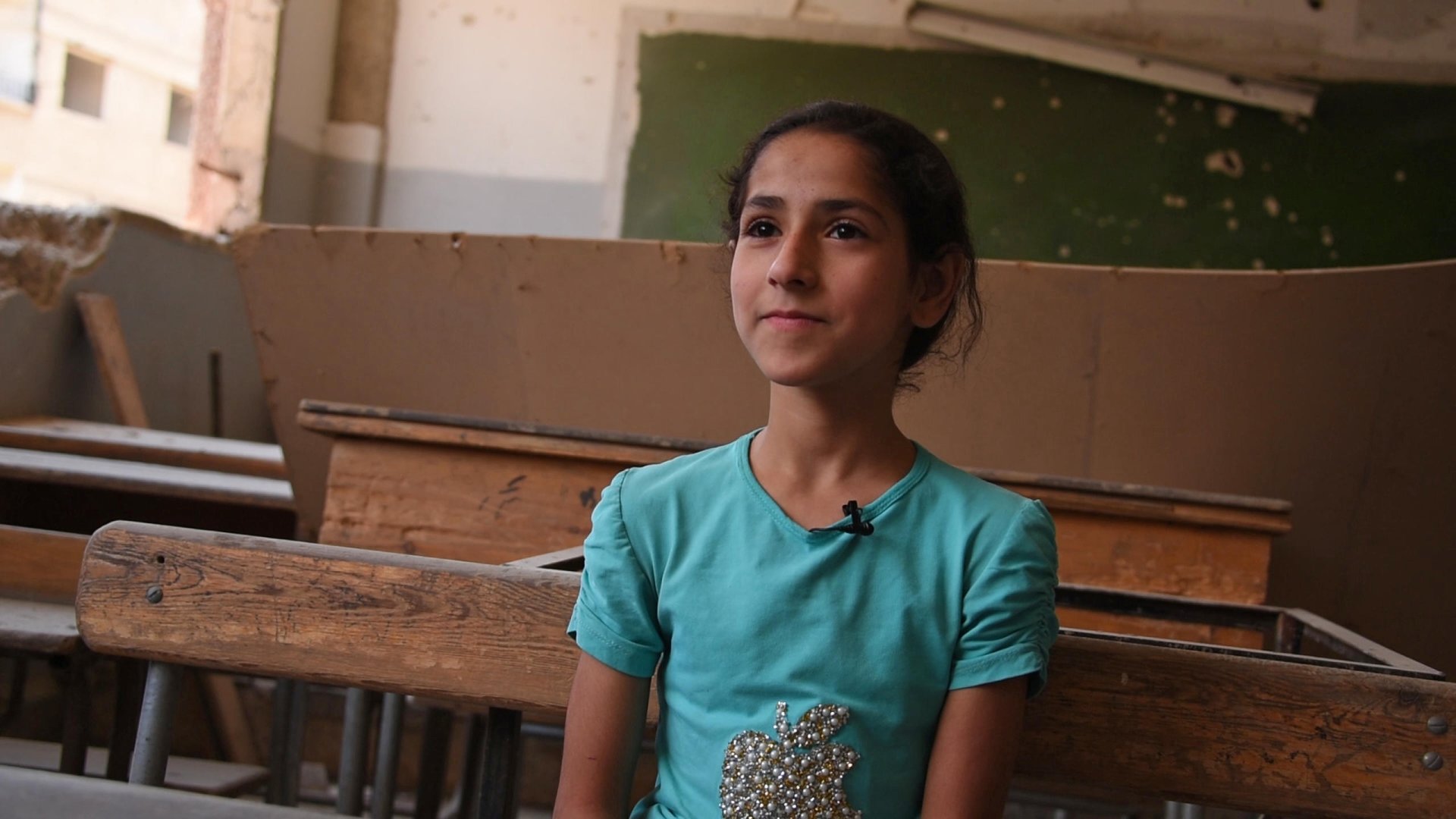 Reem, 10, from Harasta, Eastern Ghouta
“My name is Reem and I’m from Harasta. I’m 10 years old. I always come to school so that I learn. 
“We didn’t use to come to school, we were afraid of the missiles and used to stay in the basement. Even when I was in the basement I used to study. I had books and I used to study. I studied Arabic and Maths; I only had books for these two subjects with me.
“My two siblings died, it is only me and my parents now.
“My mother doesn’t like if I get low grades so she keeps teaching me so I am always the first in class.
“I used to hide whenever there was a missile launched. I was very scared. One time there was a missile that hit the basement next to us. I was terrified. I am still scared now.
“I hope the situation becomes calm just like here with no bombings or airstrikes hitting us. “I hope we can see the school without any damages or broken walls.”
Photo: Karl Schembri/NRC