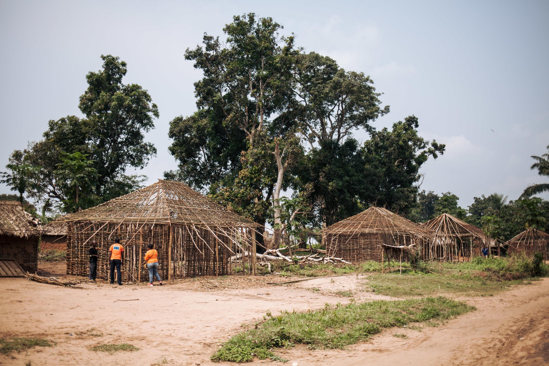 NRC staff speak with Bernard Vita, a 35-year-old merchant who is helping his foster son build an NRC-funded home in Bakuakashila, Kasai-Central.  

Bernard and the majority of the residents of this village had to flee into the forest for months after Bakuakashila was attacked by armed groups in early 2017. When they returned to their village they found everything destroyed.

Over 1 million people have returned to their homes in Kasai-Central after a year of violent conflict within the province and across the Greater Kasai Region.  Unfortunately, people who have returned have found their homes and fields pillaged and burned to the ground.  These farming communities have no shelter, no food to eat and no means of sustaining any viable livelihood.

Earlier this year, NRC visited Mbulungu and Bakuakashila, two villages ravaged by the regional conflict in 2017.  NRC used its “community-based approach” by consulting with these communities to better understand their primary needs, to properly target the most vulnerable people and facilitate their ability to choose the assistance they require.

This intervention, however, is only a drop in the ocean of the vast needs of this community.  NRC is currently the only humanitarian actor in the zone and funding is not enough to address other acute needs such as food assistance, household items and education.  The Humanitarian Response Plan is currently only 25 per cent funded eight months into the year.  Humanitarian capacity is critically low.  If donors do not act now for the people of Mbulungu and for the rest of DR Congo, it will be too late.

29 August 2018, Kasai-Central Province, DR Congo 
Photo: NRC/Aléxis Huguet