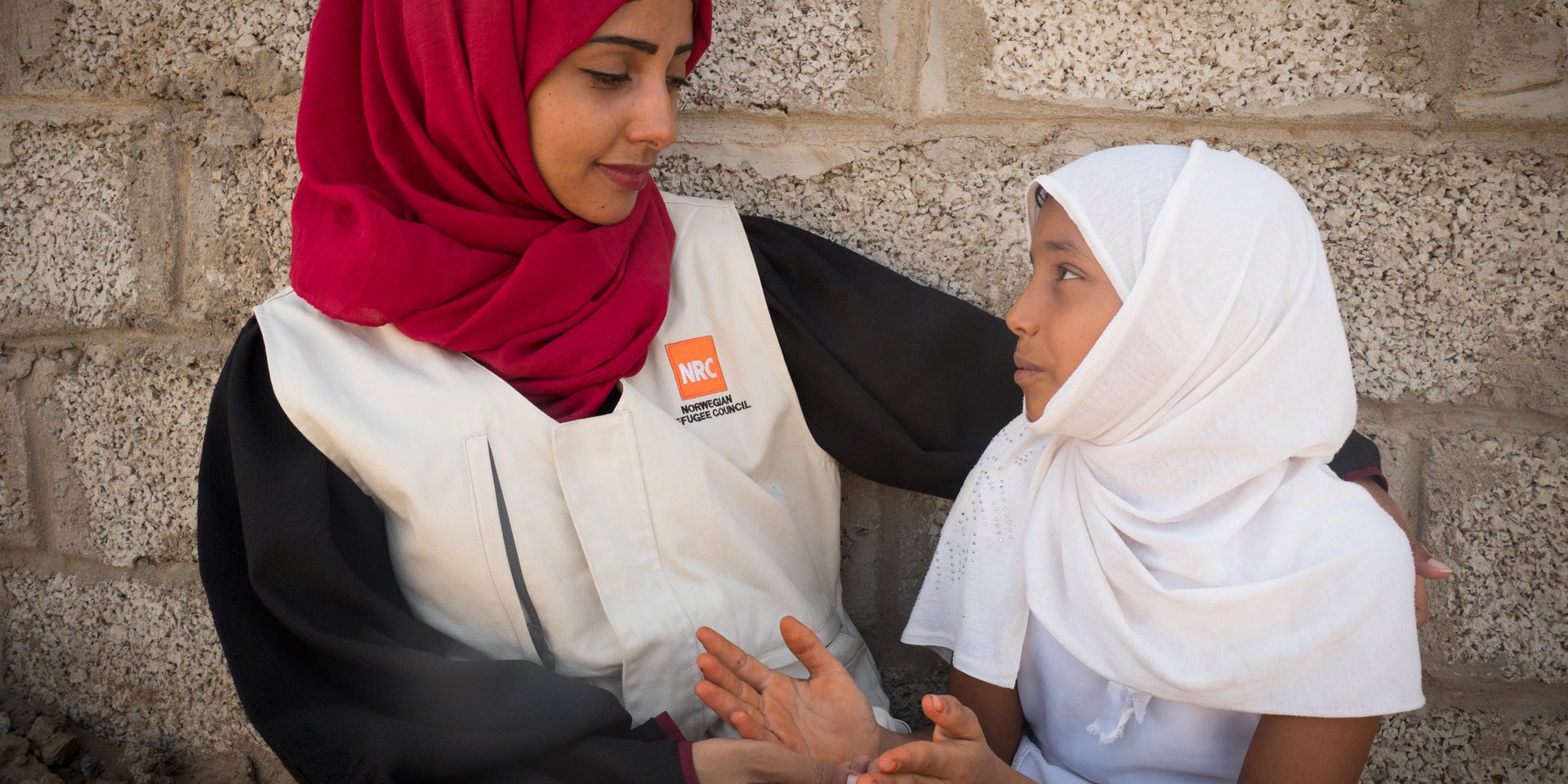 Aden, Yemen. NRC’s education assistant Malka Mohammed (26) speaking with a young girl.