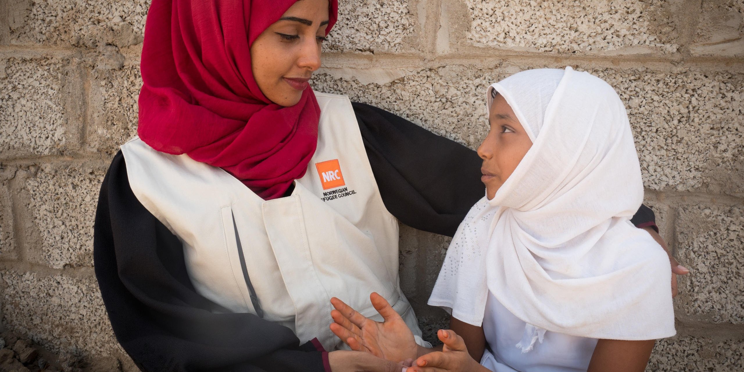 Aden, Yemen. NRC’s education assistant Malka Mohammed (26) speaking with a young girl.