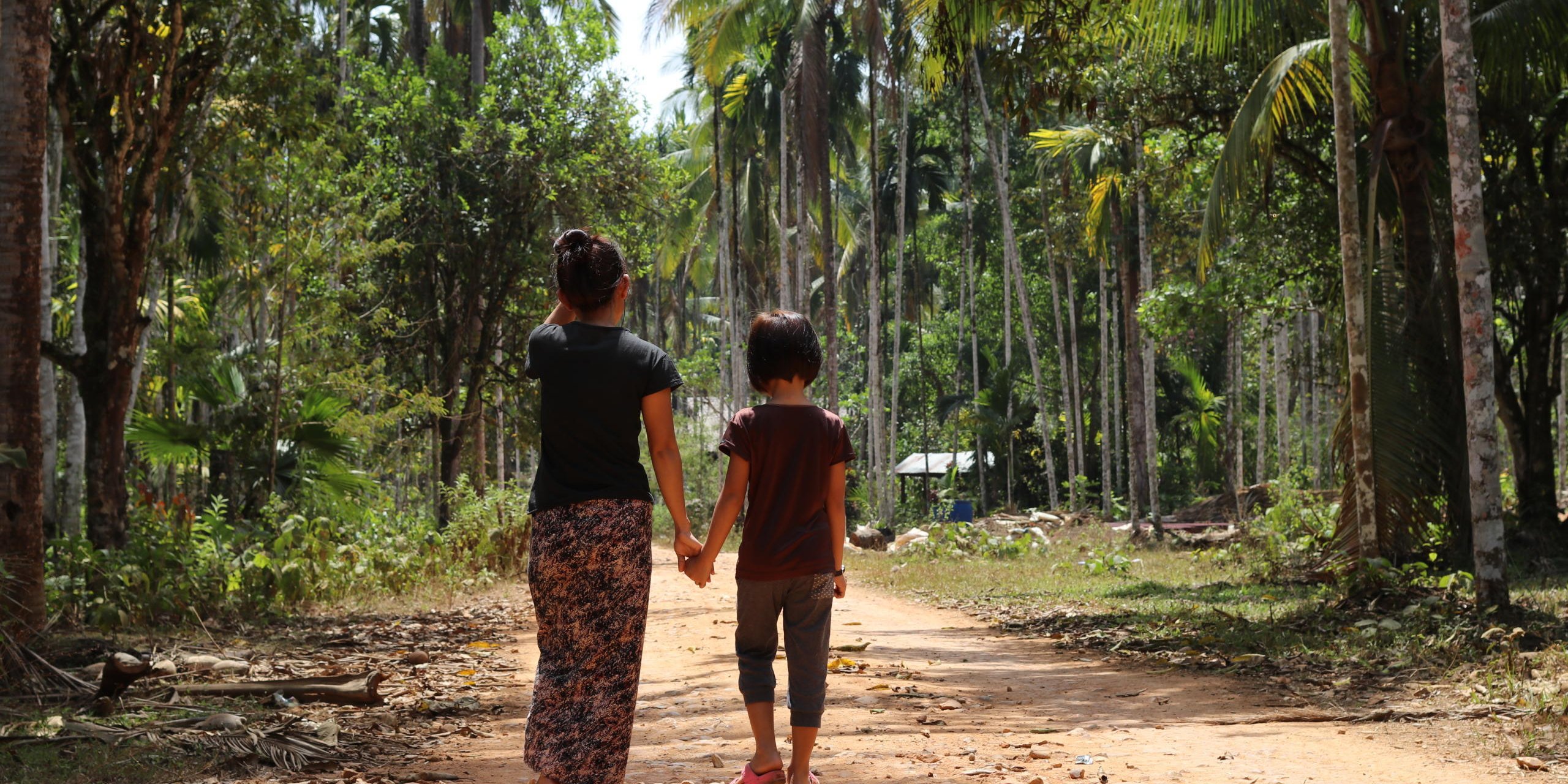 The first time she was forced to flee, Nyein, 32, was only 12 years old. That was 20 years ago, and only now is she returning to her home village to stay. 
(The names of the mother and daughter are not their real names. The mother chose their fake names: Nyein means “peace” and Yone Lay means “rabbit”)
The whole village had to flee to the forests every time fighting between the government army  and Karen National Liberation  army (KNLA) drew close to their village. At the most, all the 60 families in the village had to hide in the forest for three months.
In the forest
“In the forest we were a big group, so we chose a group leader who would delegate everyone’s duties. The men went hunting for monkeys and the women picked vegetables,” said Nyein.
The fighting continued, and the villagers went back and forth between their home and the forest. In 2001, the fighting stopped, but the villagers did not feel safe and some of them continued going to the forest every now and then. 
Forced to serve the army
The government army  continued passing the village, and every time they passed by, they forced the head of every family to work for them for free, bringing them food or carrying their loads. 
Nyein was the head of her family. During the fighting days, her father, the head of the village, was killed by the government army. They suspected him of sharing information with the KNLA. Her four older brothers were already married and her mother was old. 
Nyein was forced to work for the same group that killed her father.
“I was very worried and felt suffocated,” she explained. She did not want to continue living like that.
Thailand
In 2005, Nyein made up her mind. Her father had passed away, her brothers were married and her mother could not afford her studies. She left her village and headed to Thailand. 
She had heard that people made good wages there and she could also get the chance to go to school. Her mother let her leave on one condition, that she would not only work, but started studying in Thailand. 
She arrived at a refugee camp in Thailand. For the first six months she was not able to find a job, and she stayed in the camp. Then, through a friend, she was employed as a nanny. Later, she had a job as a waiter for a while. 
Three years passed without Nyein having any contact with her family. Her life in Thailand was work and study. 
She worked for six months, studied English at night, then went to high school for four months during the day and then back to work for six months with English in the evenings.
In 2008, she met her husband, also a Burmese, but from another ethnic group.
After their now eight-year-old daughter was born, they continued living in the camp, working during daytime and tutoring the daughter in the evenings.
Home at last
Last summer, Nyein returned back to her home village. She brought her husband and their 8-year-old daughter, Yone Lay.
In Thailand, she could earn good money, but she was worried that her daughter would not get a citizenship in Thailand, and that she would have to work instead of going to school.
Also, rumours had it that the camp in Thailand was going to be relocated, which would mean that all those living in it would yet again have to move. 
“I heard that the new government had signed a peace agreement with the Karen National Union (KNU), and trusted that it would be safe to return.”
She had missed her home village, especially at Christmas. The family returned to the village the spring of 2016 and her daughter started going to the local school.
Nyein has hopes for her daughter’s future:
“I want her to be well educated, have a good job, a citizenship in Myanmar.”
Since the family moved back, NRC has been I the village two times (In June 2016 and February 2017) to give ID-cards to those who does not have them. The parents, who already have the ID-cards, asked NRC whether their daughter would be eligible to have a ID-card as well, and NRC told them she would be when she reached the age of ten.
Today
Today, Nyein has opened a little shop in their house in the village, where she sells beetle nuts, a few grocery articles and medication. She took a basic medical course in the camp in Thailand, and is now giving the villagers medical advice and medicines. Those who come by to seek her advice often have no money, and as she cannot turn away a sick neighbour – her shop is not going very well. 
Her husband works as a volunteer for a local NGO who is working to take care of the forest.
Future of Myanmar
“My father was killed because of the conflict and the suspicions between the warring parties. I wish for peace. I want freedom of movement and for the suspicion that has existed between groups and people for so many years to go away. I want people to trust each other and live together in harmony.”
“For now, we are just trying to make the best of things. Although I’m quite happy, I would wish for better conditions for my family.”
Her daughter just finished 2nd grade and is starting in 3rd grade in June, after the holiday (Summer holiday lasts from March to the end of May)
In January 2017, the new school in the village opened. The school was built thanks to NRC who financed the new building, and is providing school material such as school bags and notebooks.
“The old school was always covered in dust, it did not have good hygiene conditions,” said Nyein, “the new school has a white board, not a blackboard with charcoal.”
“Yone Lay loves to go to school, she loves writing and English. Her teacher says she is good in languages but not so good in maths.”
When I ask the daughter what she wants to become, she whispers in her mother’s ear that she wants to be a doctor.”
---
In Myanmar, the Norwegian Refugee Council (NRC) helps building schools in villages situated in remote areas and homes for local teachers, and we distribute school material such as school bags and note books. 
In the southeast, we are working together with the authorities to give people information about the importance of civil documentation and distributing ID-cards to those who do not have it. With the ID-card, they have access to public services such as medical services and the possibility of opening a bank account, secondary education and they have freedom of movement. 


Myanmar – the context
After fifty years of military rule, Myanmar welcomed a new era of democracy and reform with its first civilian elections in 2015. However, the newly formed government still faces the same issues as before. 
Known as the “longest running civil war,” Myanmar has been tormented by internal conflicts led by ethnic groups struggling for representation since the country’s independence in 1948. Hundreds of thousands have been displaced in the decades-long conflict. Every day, people are being displaced by violence, leaving everything they own behind. Years of fighting have forced many to flee over and over again.
Since late 2011, the government has signed ceasefire deals with the majority of ethnic armed groups in the country, and in October 2015, the government negotiated a nationwide ceasefire agreement with eight of the largest ethnic armed groups. Still, some groups have refused to sign the agreement, and they continue negotiating with the government.
In addition to conflict, disasters and, increasingly climate change are forcing people in Myanmar to flee their homes.
In Myanmar, NRC helps displaced people and people affected by conflict through building disaster-resistant schools and wells, providing civil documentation, youth education and camp coordination. We have been working in the country since 2008 and all of our activities are managed from seven field offices within the Southeast Region, Kachin and Rakhine States.
We are working for people in Myanmar to have the right to education, work and property, so that they can live safe and independent lives.


Photo:NRC/Ingrid Prestetun