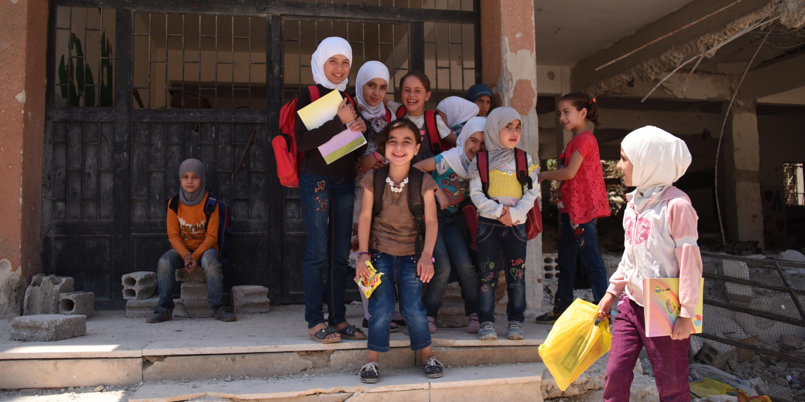 Children living in Harasta, Eastern Ghouta, flock to school to catch up on years of missed education. Years of siege ended with a peak in fighting last March. With most of the neighbourhood in ruins, tens of thousands of Syrians are still displaced with no home to return to, but hundreds have also returned to what remains of their houses or stayed all along.
Despite all they have been through, these children are happy to be back to school. This one in Harasta houses 725 children, with parts of it completely destroyed and others badly damaged.
Photo: Karl Schembri/NRC