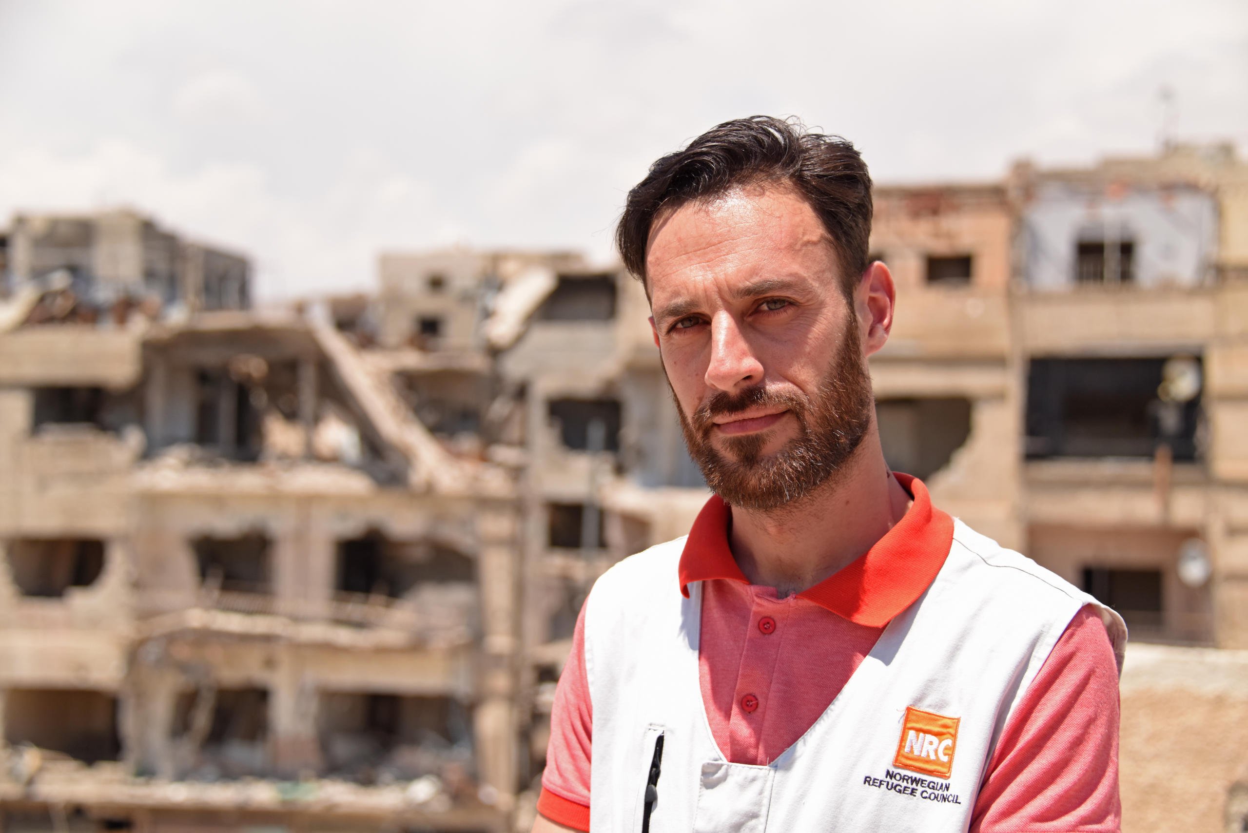 Mustafa Ghrieri, NRC Shelter Officer
“I feel both sad and happy. I’m sad to see a view like this, with buildings and schools, and people are suffering from what happened. And I’m happy for coming back, seeing people wanting to go back to their lives, children wanting to go back to school.
“I was living in Eastern Ghouta; unfortunately until now I can’t go back to my house with my family. Hopefully we’ll come back soon.
I want to come back to help people to rebuild their schools and maybe in the future their houses here. It’s important because in Syria we’re one big family. I feel that we have to help each other. If I see children I feel they are my brothers, my sisters. I hope that in the future we can come back to like it was before the crisis; working as before, happy as before, we can go back and forth safely to our houses.
“When I see children going back, to this school especially, I see that they want to learn, they like their school. Even if they maybe have to walk a long distance from their home, and there might be fear among their parents who send them but they actually want them to learn. I hope, as an engineer working on the rehabilitation of schools, to help them to achieve their goal and maybe we can see them in the future as engineers and doctors working in Syria. Schools like this with so much damage need funding support from our donors.”
Photo: Karl Schembri/NRC