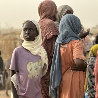 Fördrivna barn och vuxna samlas i ett tillfälligt bosättningsområde efter att ha tvingats fly undan våld och osäkerhet.