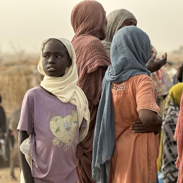 Fördrivna barn och vuxna samlas i ett tillfälligt bosättningsområde efter att ha tvingats fly undan våld och osäkerhet.