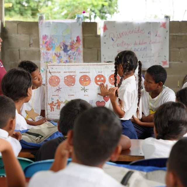 Lärare undervisar i ett klassrum framför en whiteboard.