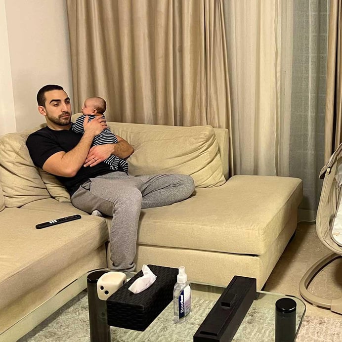 En pappa och hans bebis tittar på nyheterna hemma.