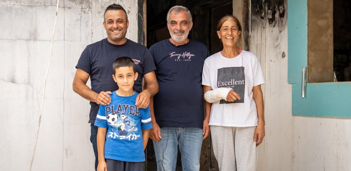 Familj som står utanför sitt hem.