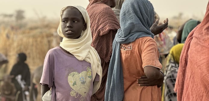 Fördrivna barn och vuxna samlas i ett tillfälligt bosättningsområde efter att ha tvingats fly undan våld och osäkerhet.
