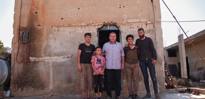 Ahmed Jamil tillsammans med fyra familjemedlemmar framför sitt hus