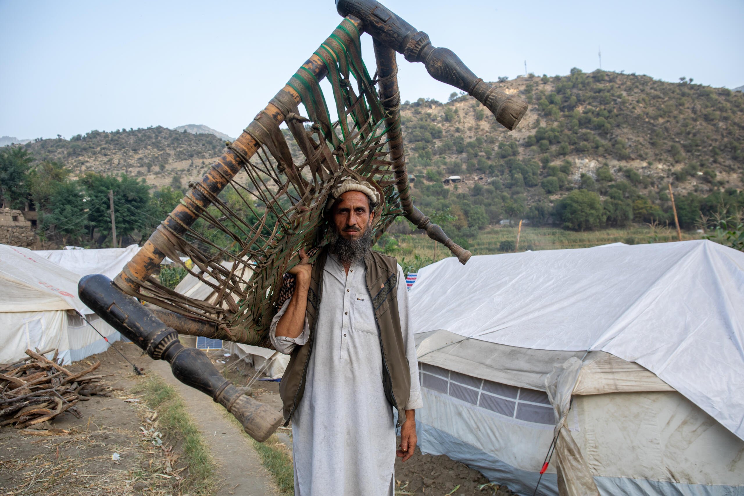 En man b&auml;r sina tillh&ouml;righeter genom ett tillf&auml;lligt bos&auml;ttningsomr&aring;de d&auml;r m&auml;nniskor lever efter att ha tvingats fly sina hem.