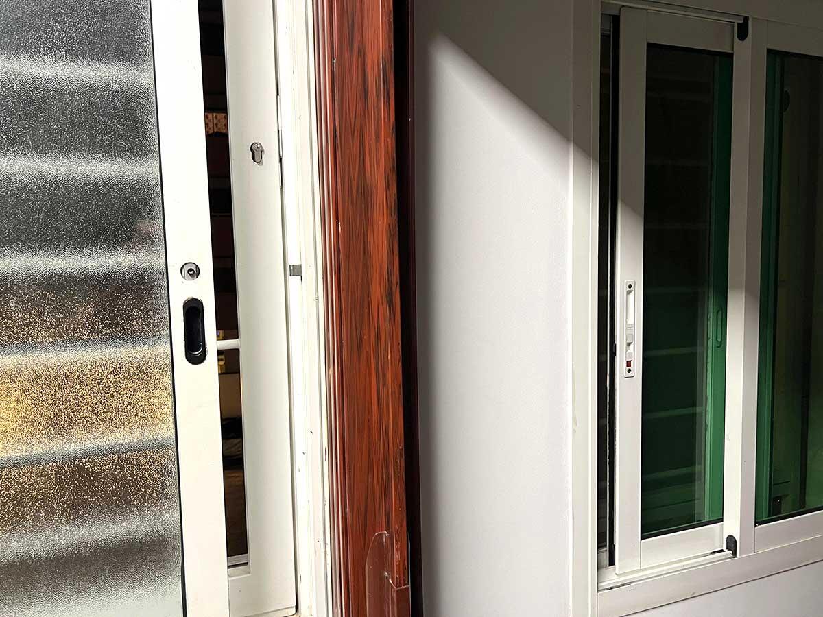 En l&auml;genhetsd&ouml;rr st&aring;r p&aring; gl&auml;nt. Ljuset fr&aring;n utsidan faller in genom den &ouml;ppna d&ouml;rren och genom f&ouml;nstret bredvid.